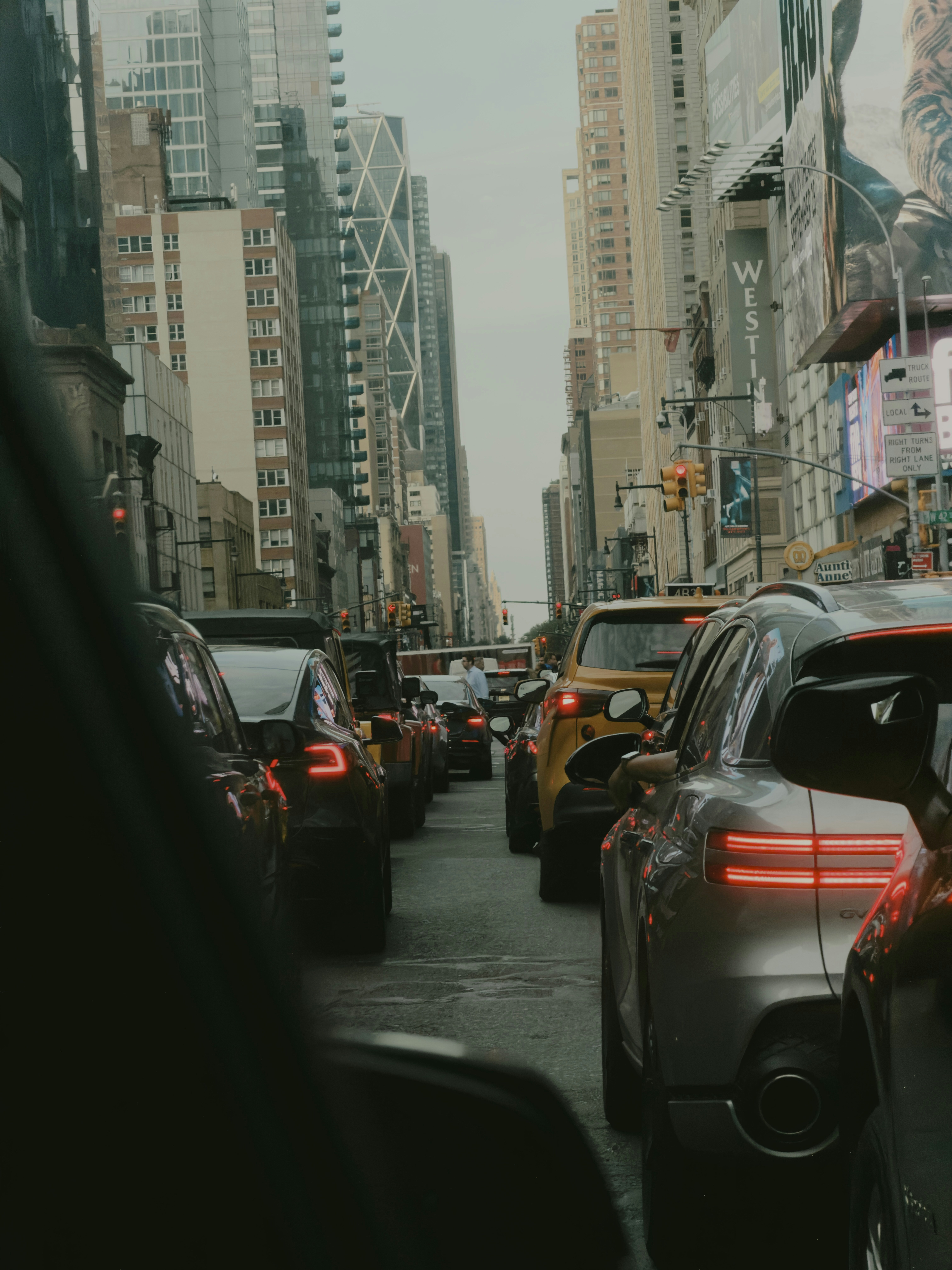 Traffic congestion on a busy city street lined with tall skyscrapers