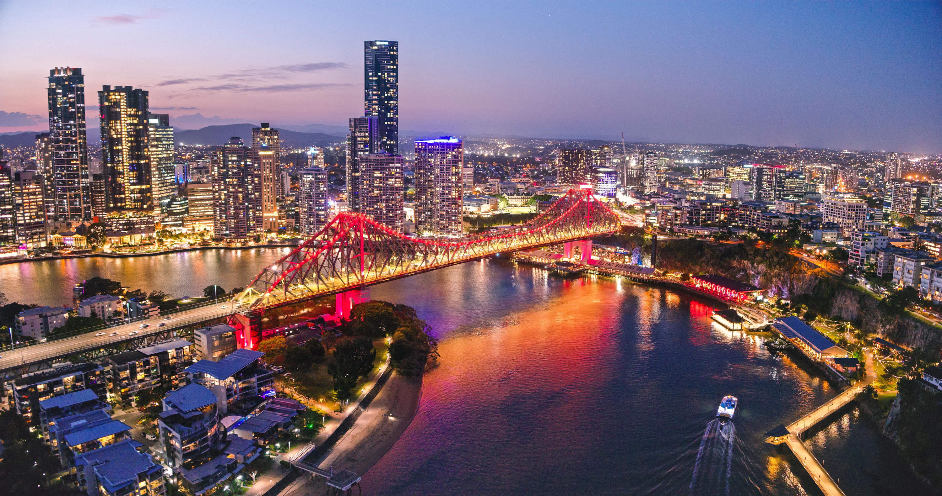 The Story Bridge illuminated in red over the Brisbane River at night