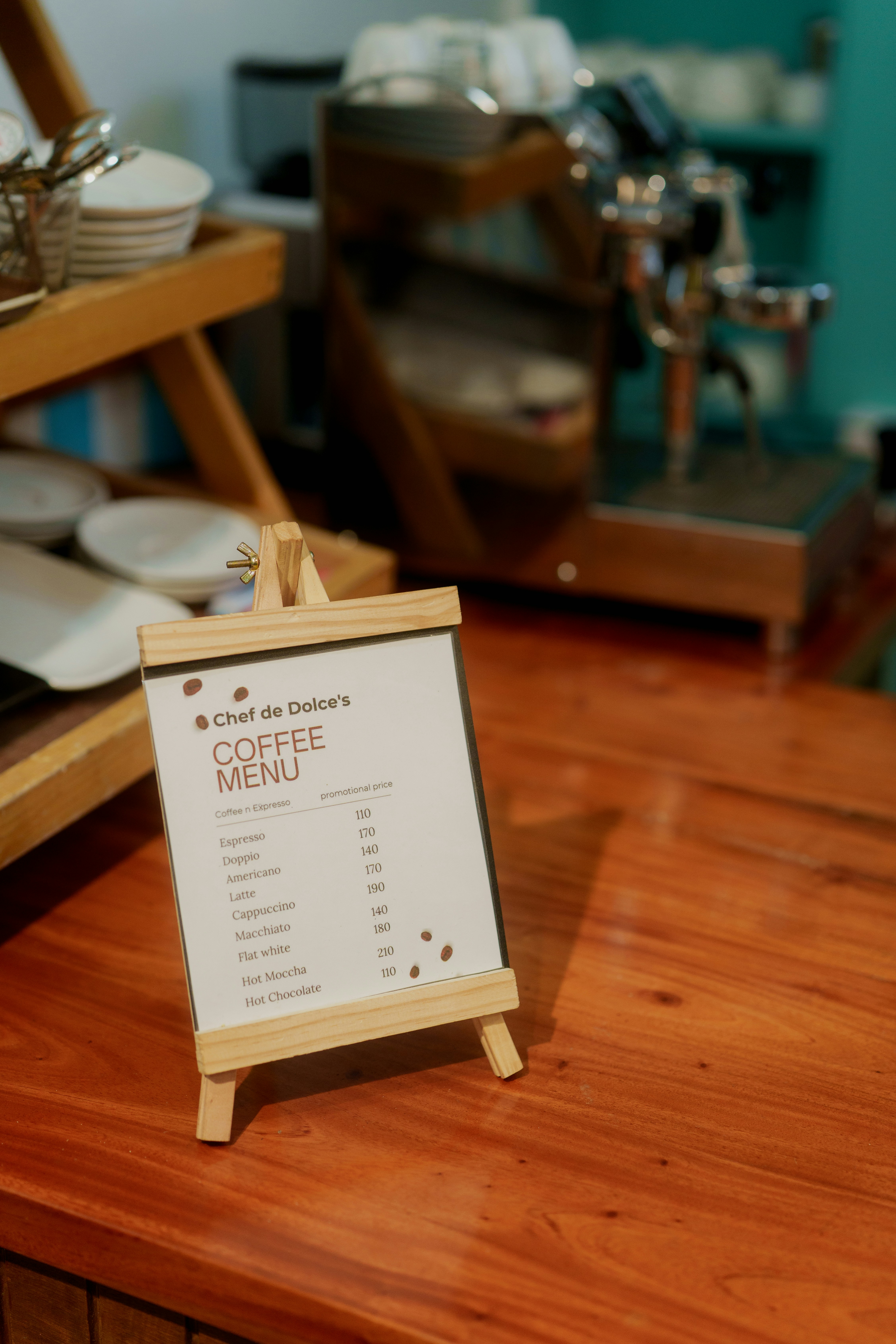 A coffee menu on a small wooden easel on a cafe counter
