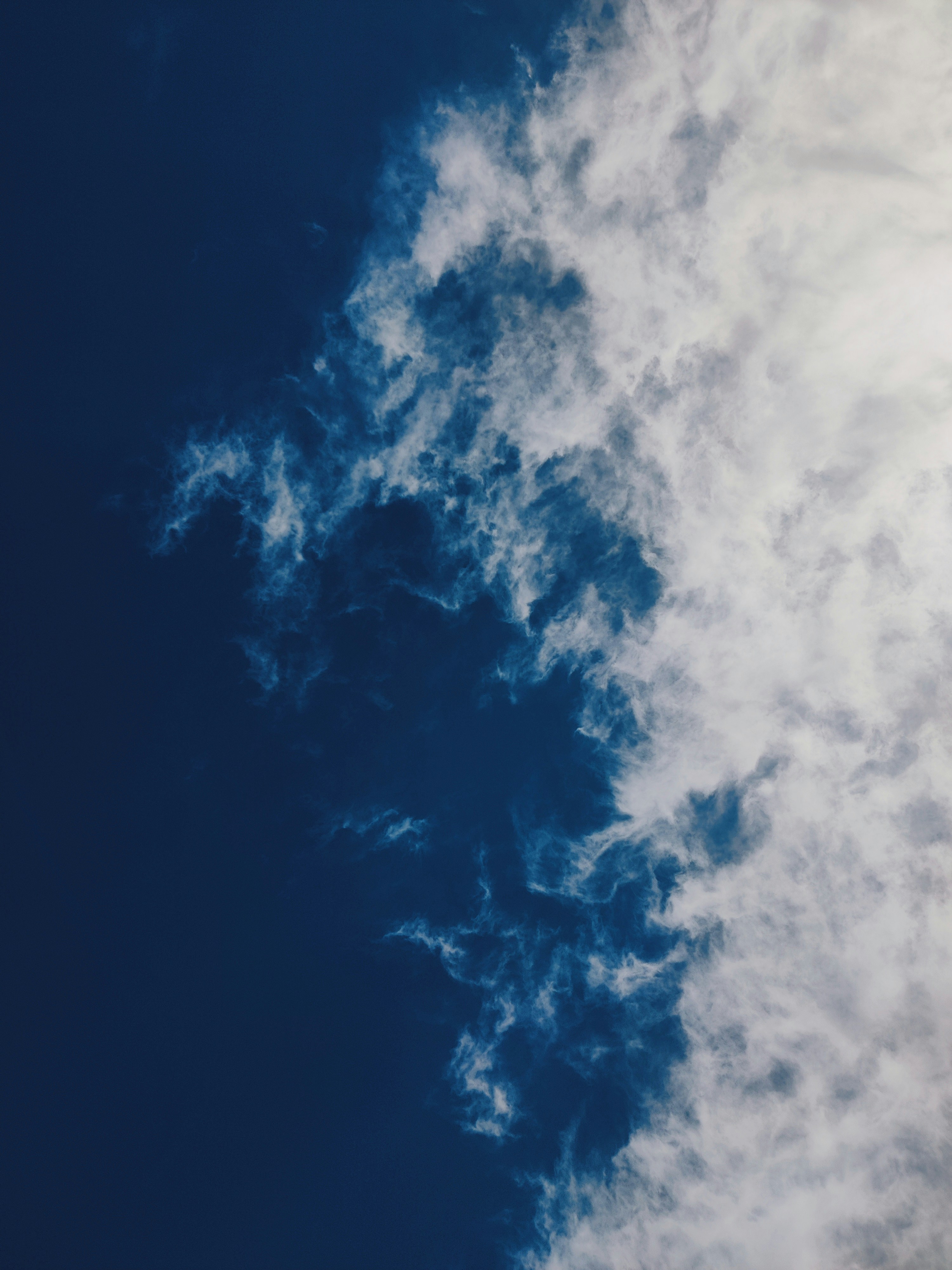 Wispy white clouds drifting across a deep blue sky