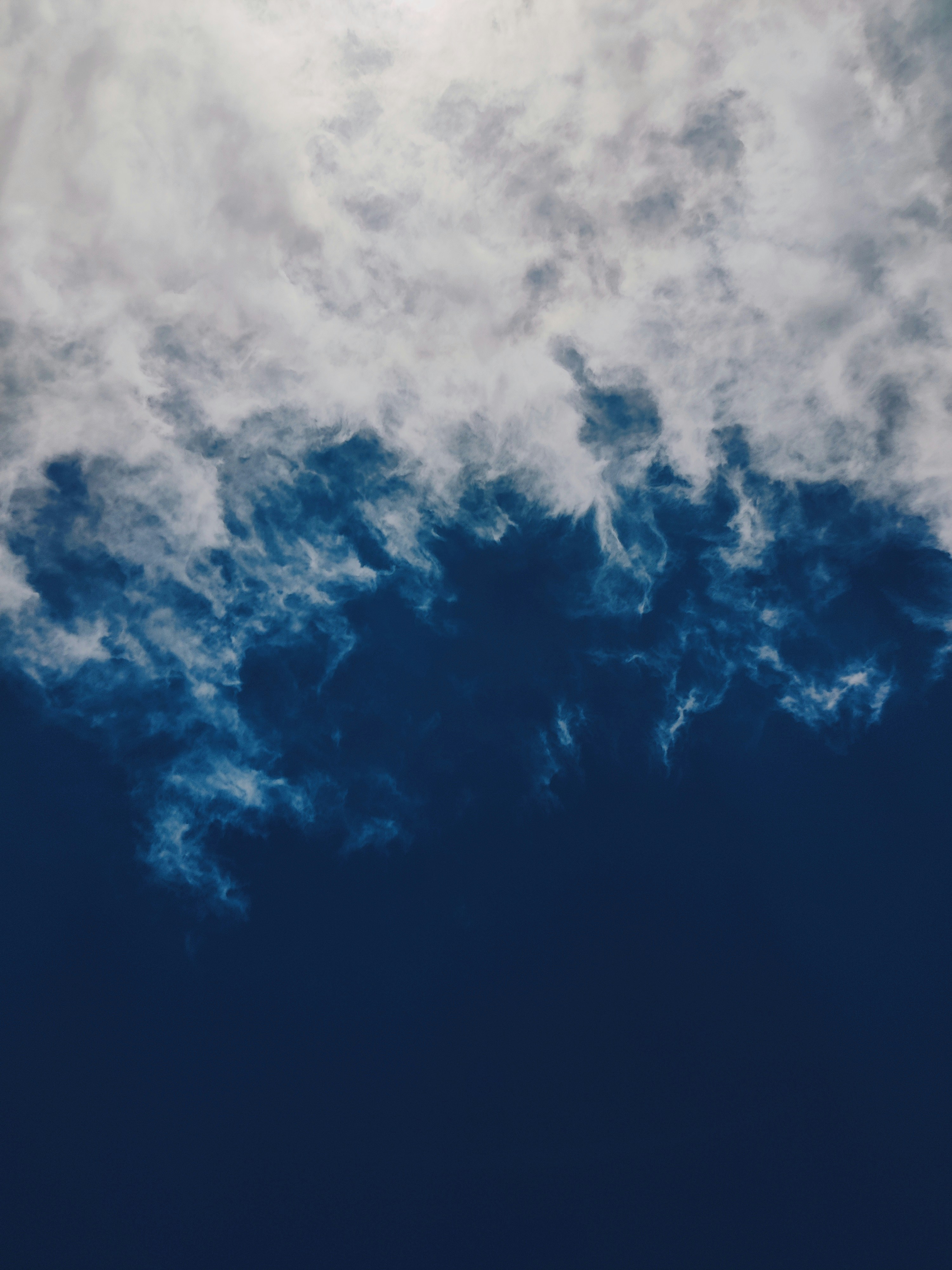 White wispy clouds drifting across a deep blue sky