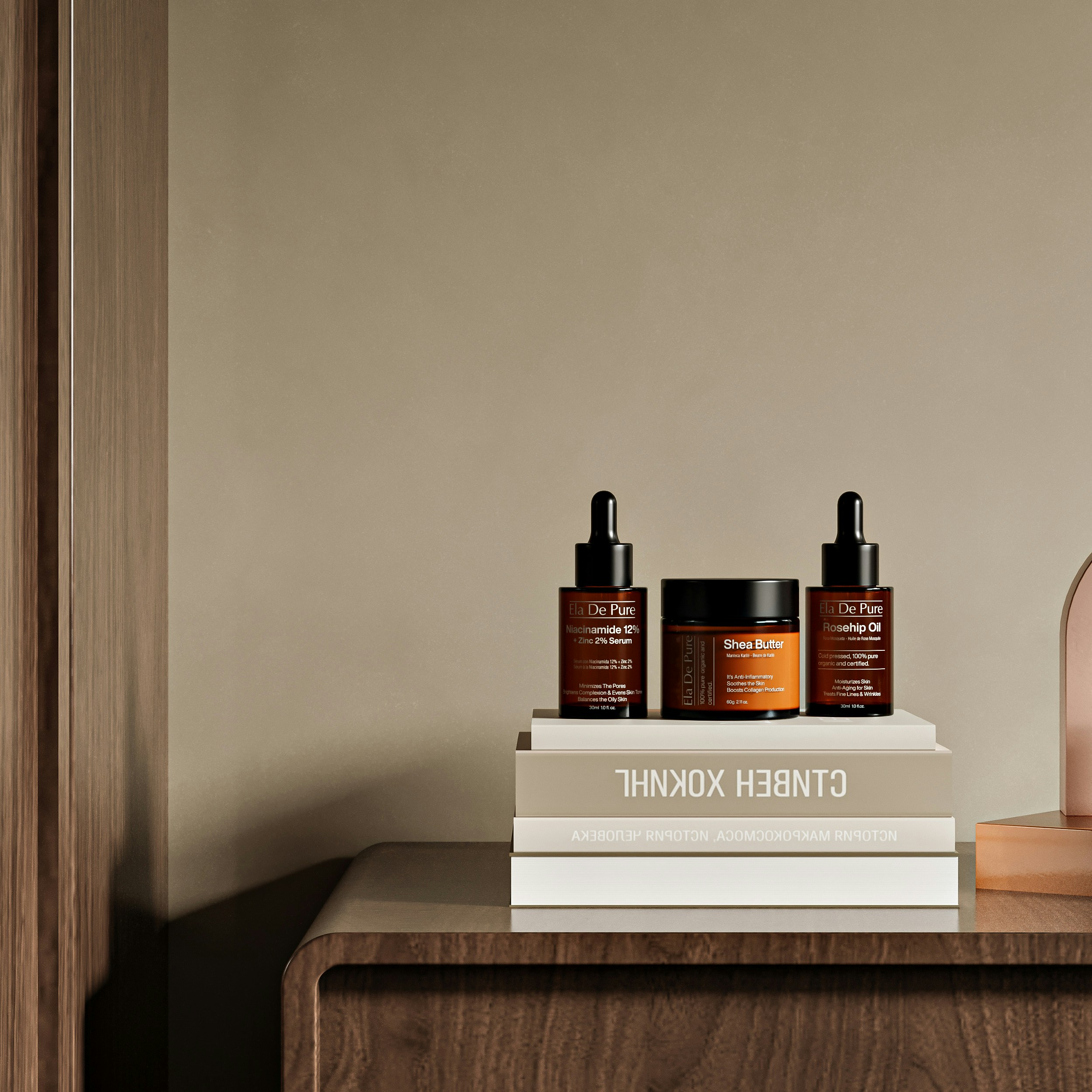 Three skincare bottles on a stack of books on a wooden table