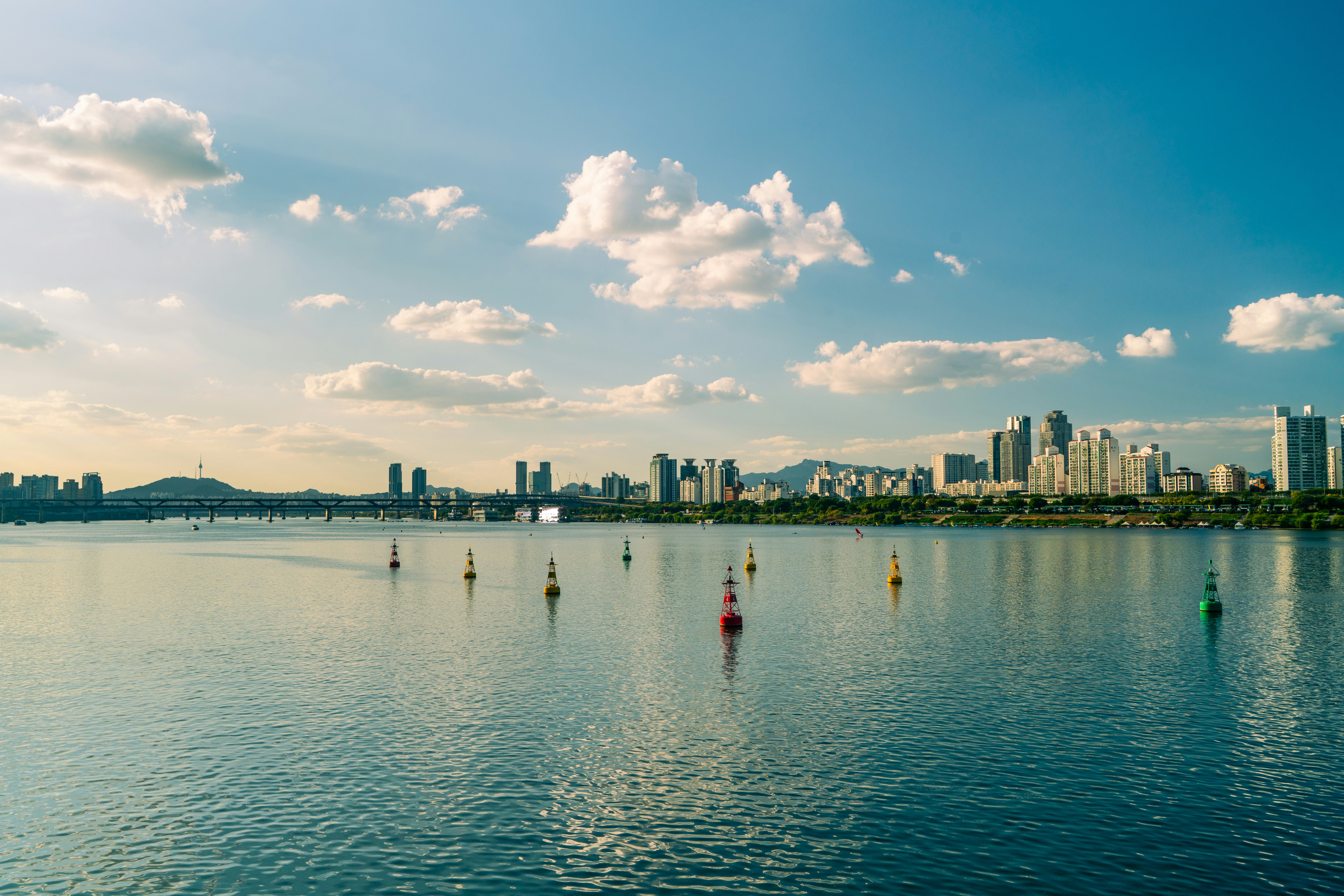 Colorful buoys floating on the Han River with the Seoul skyline in the distance