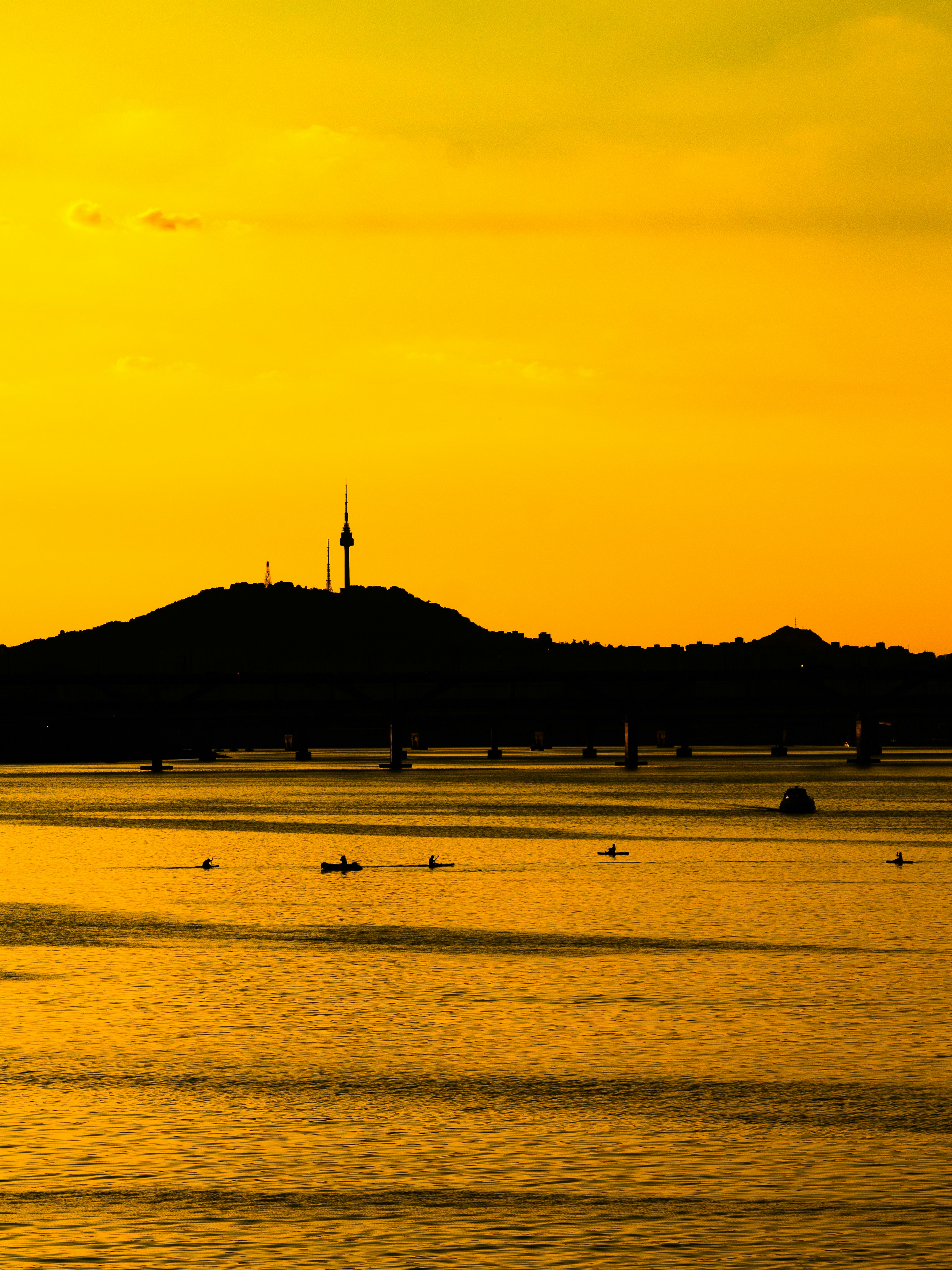 Kayakers on the Han River with N Seoul Tower in the distance at golden hour