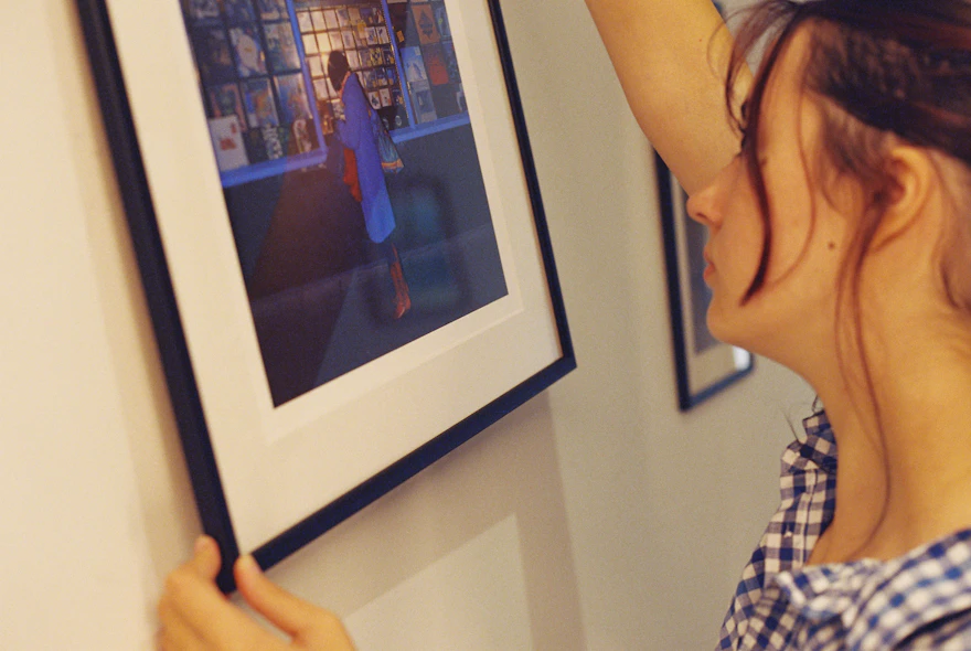 A framed picture being hung on a wall