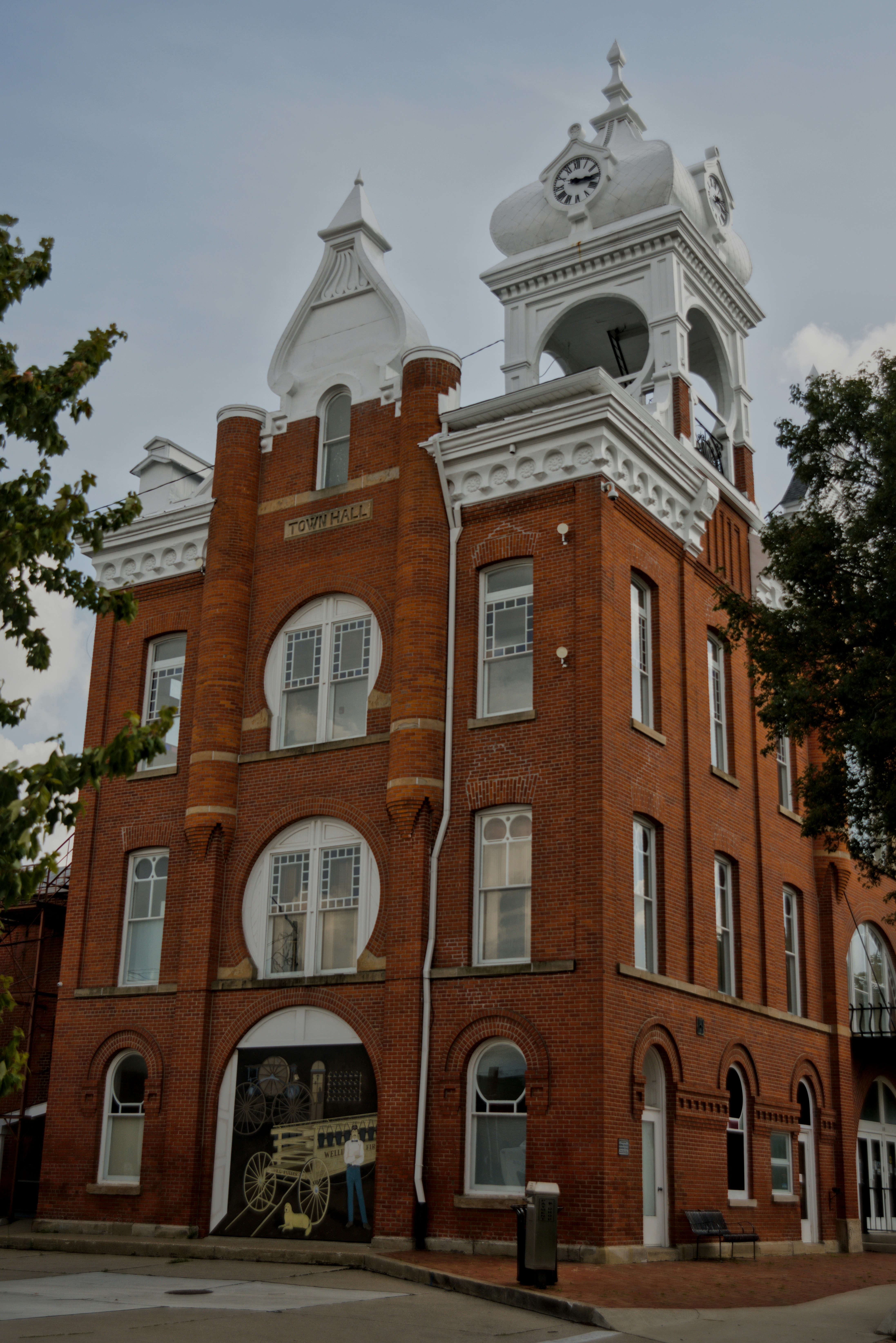 A historic red brick town hall building with a white clock tower