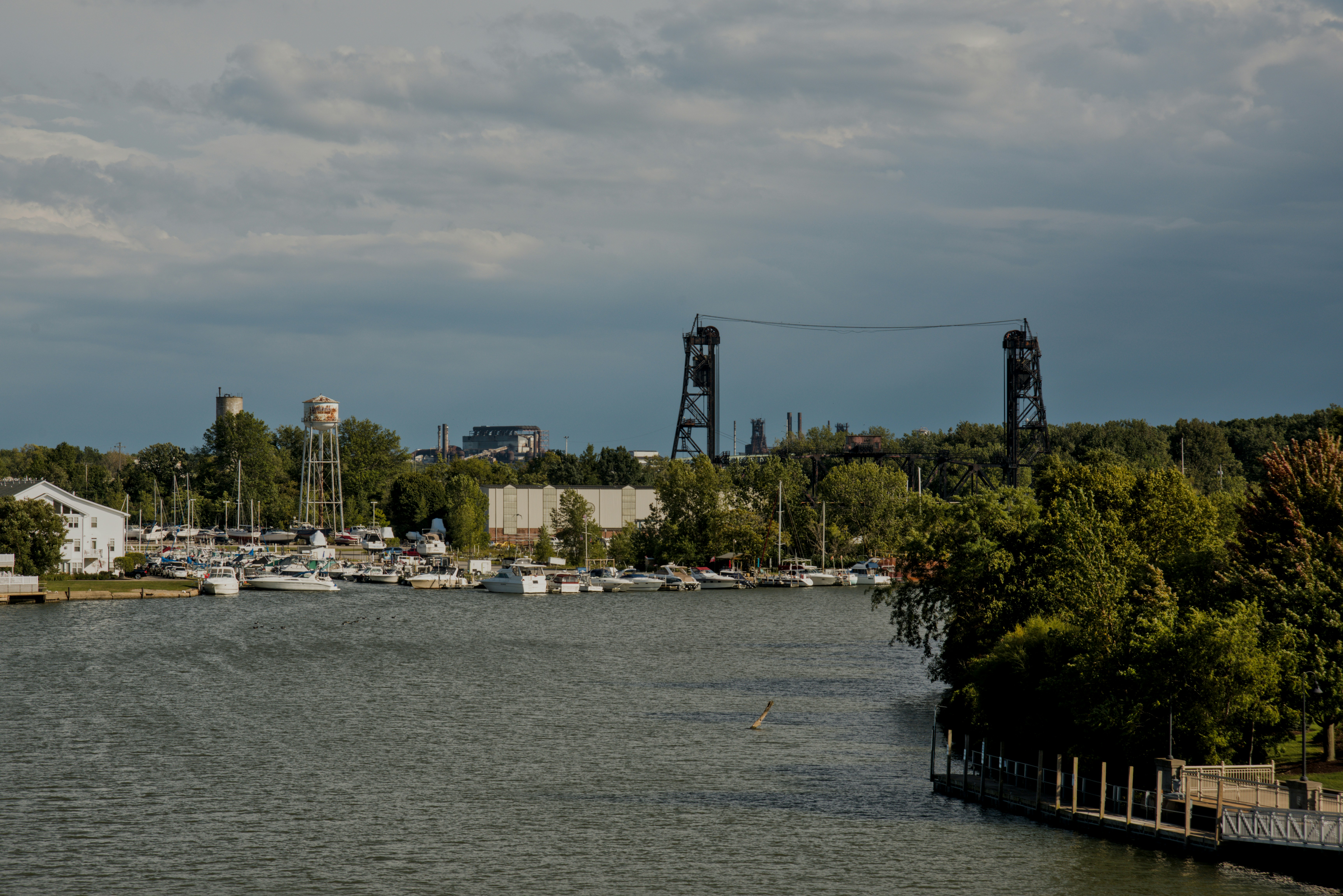 Boats moored at a marina near a water tower and a lift bridge