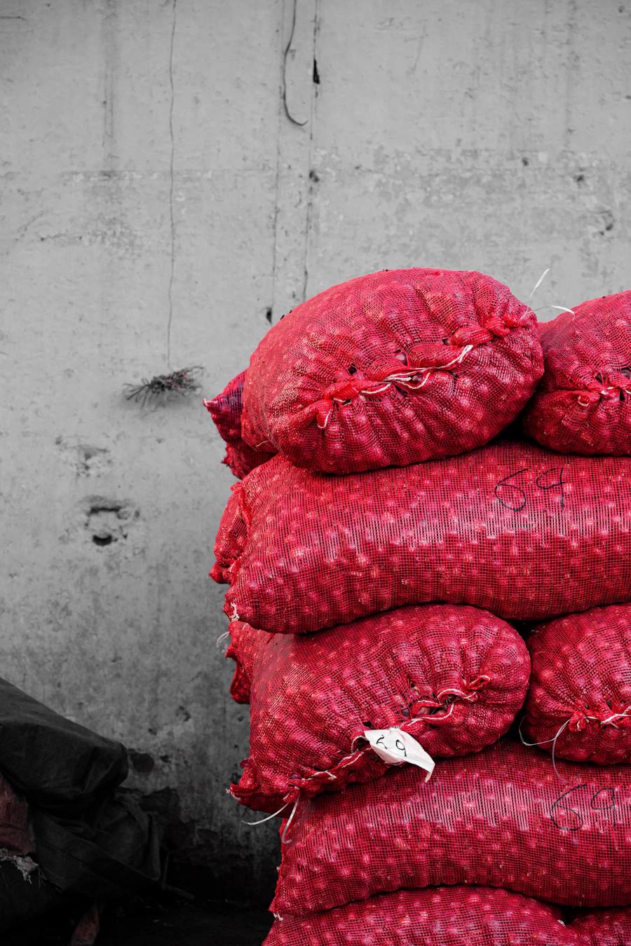 Red mesh bags filled with onions, stacked high
