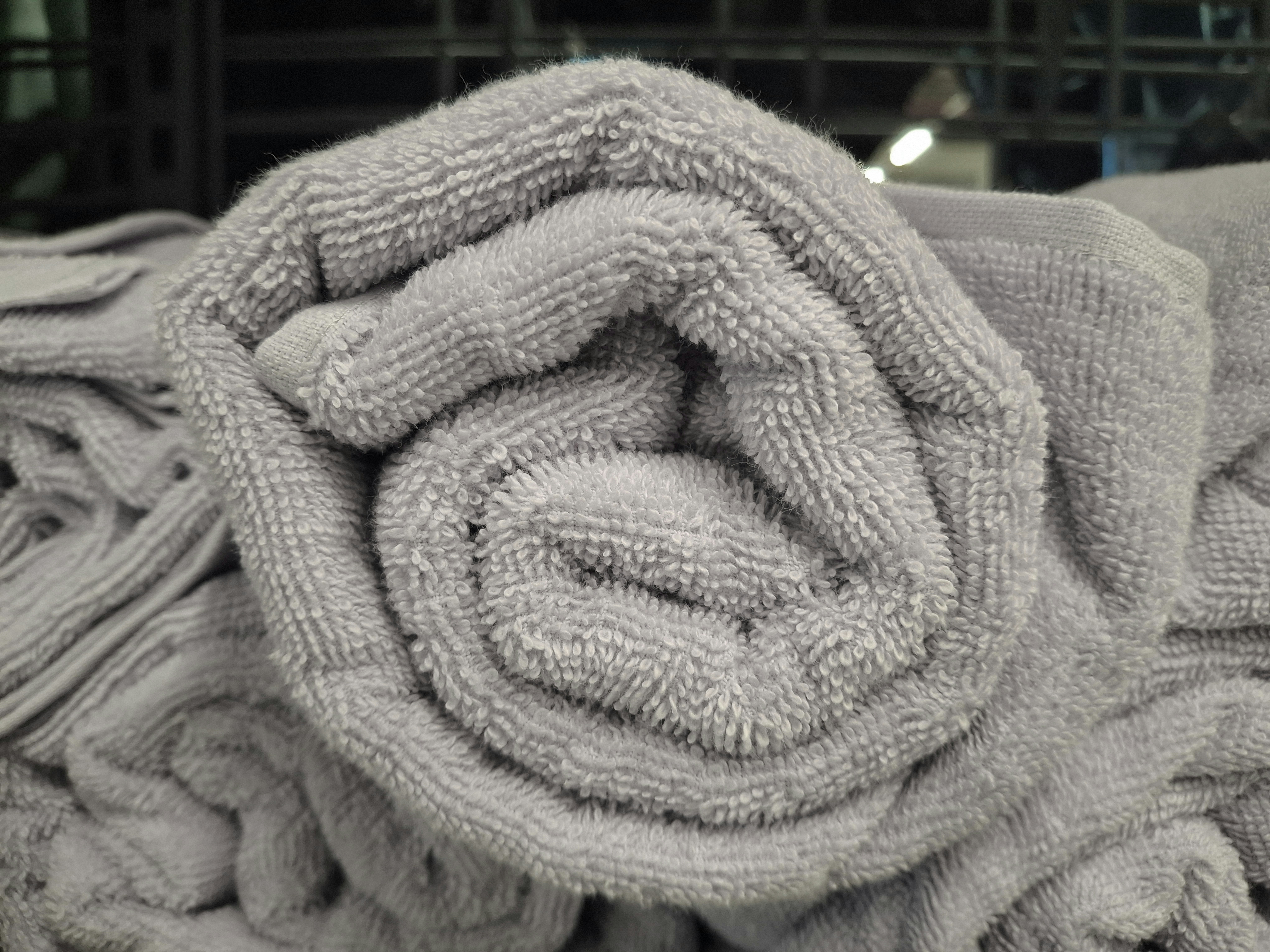 Neatly folded stack of fresh bed and bath linen in natural light