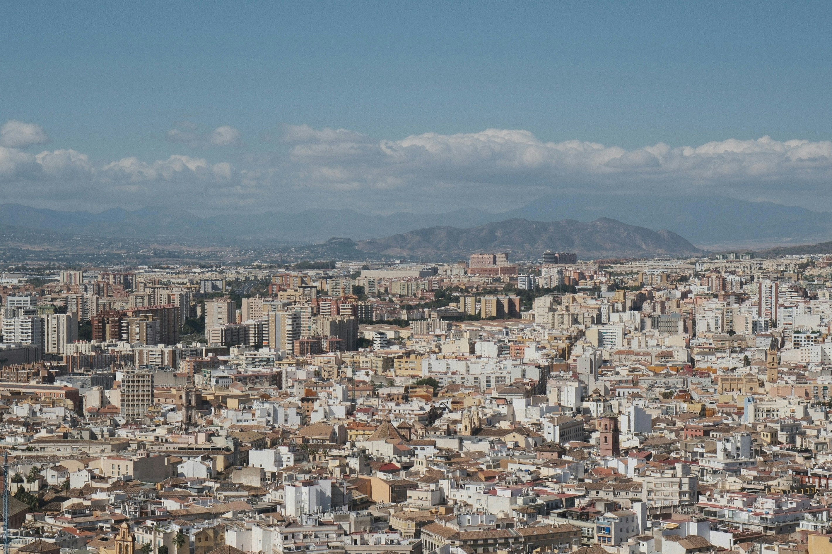 Vista aerea di una città fitta con montagne in lontananza
