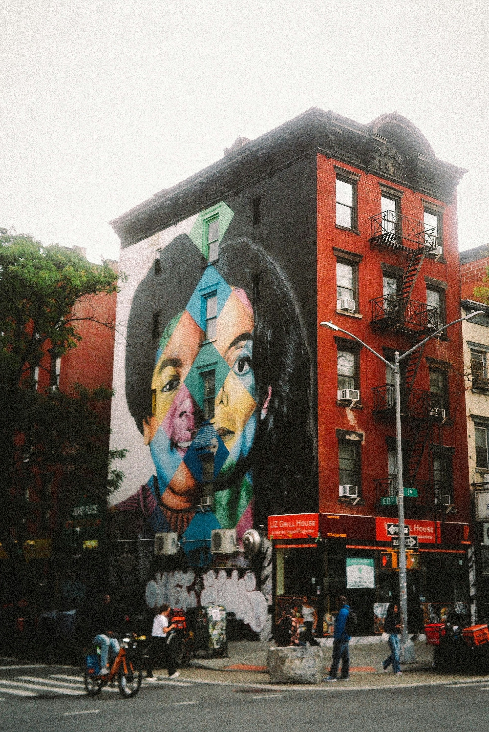 Une grande fresque colorée d’une personne sur le côté d’un bâtiment en briques rouges