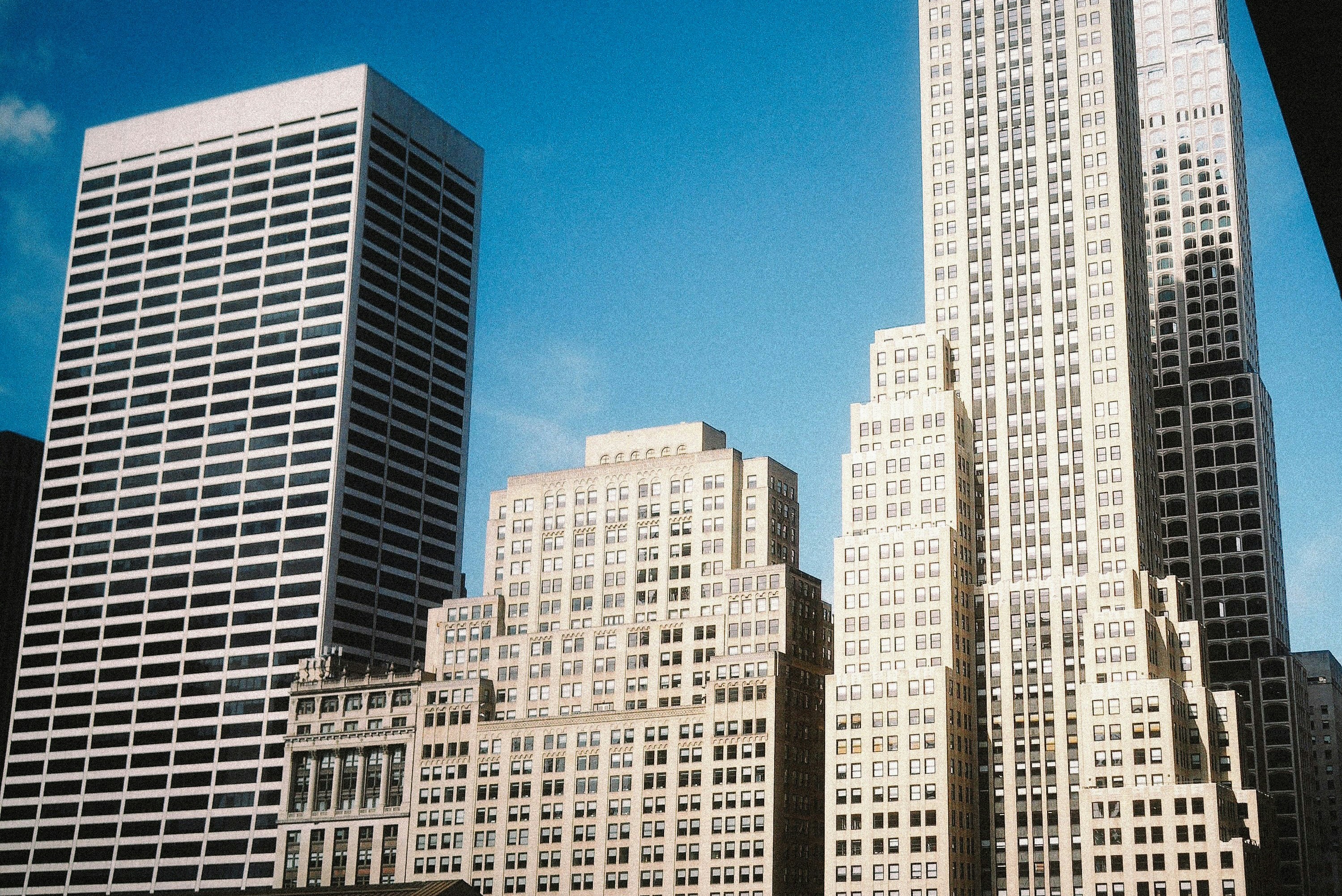 De hauts gratte-ciel avec des fenêtres grillées sur un ciel bleu clair à New York