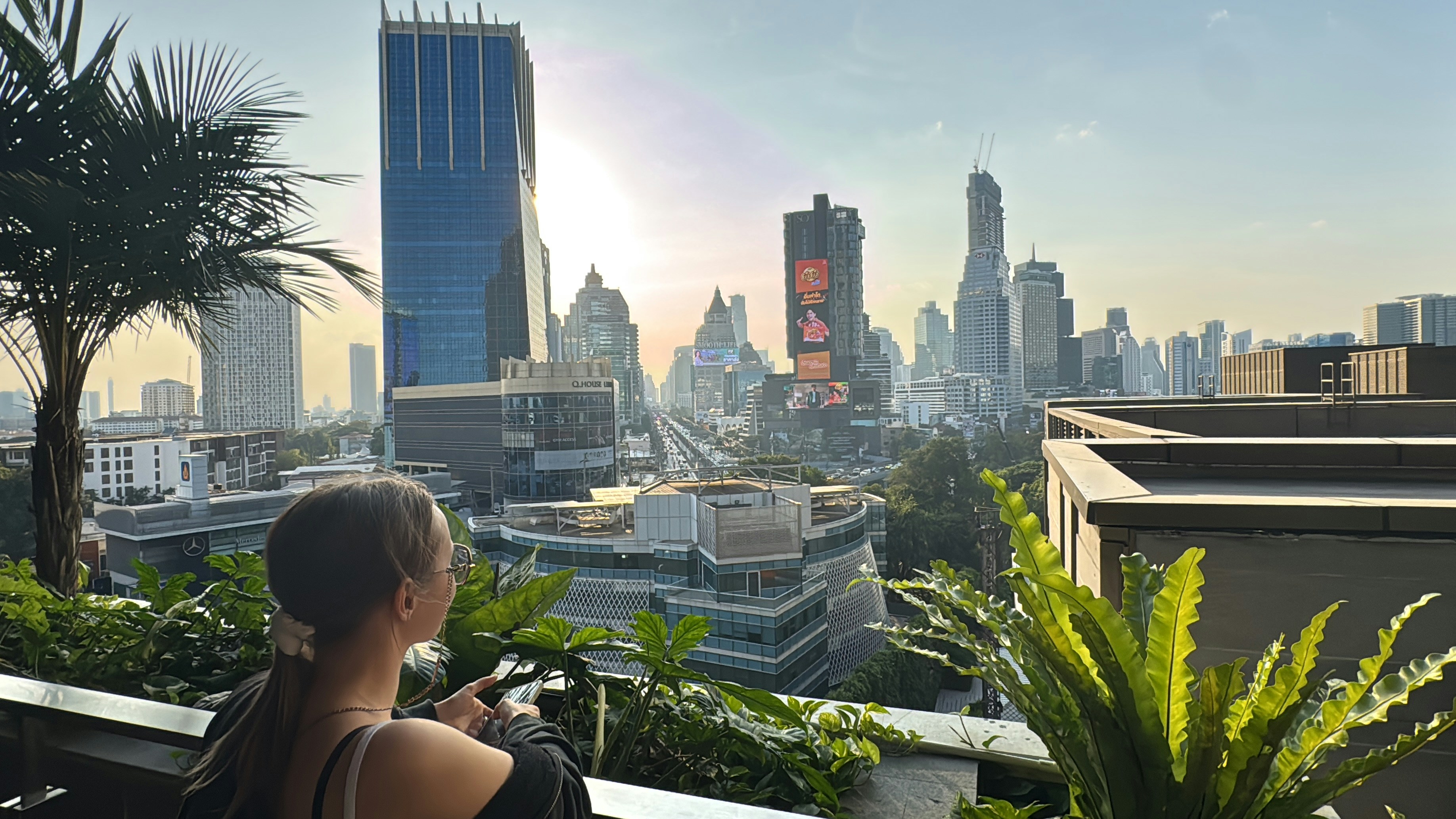 Una persona mirando el skyline de una ciudad con rascacielos en la hora dorada