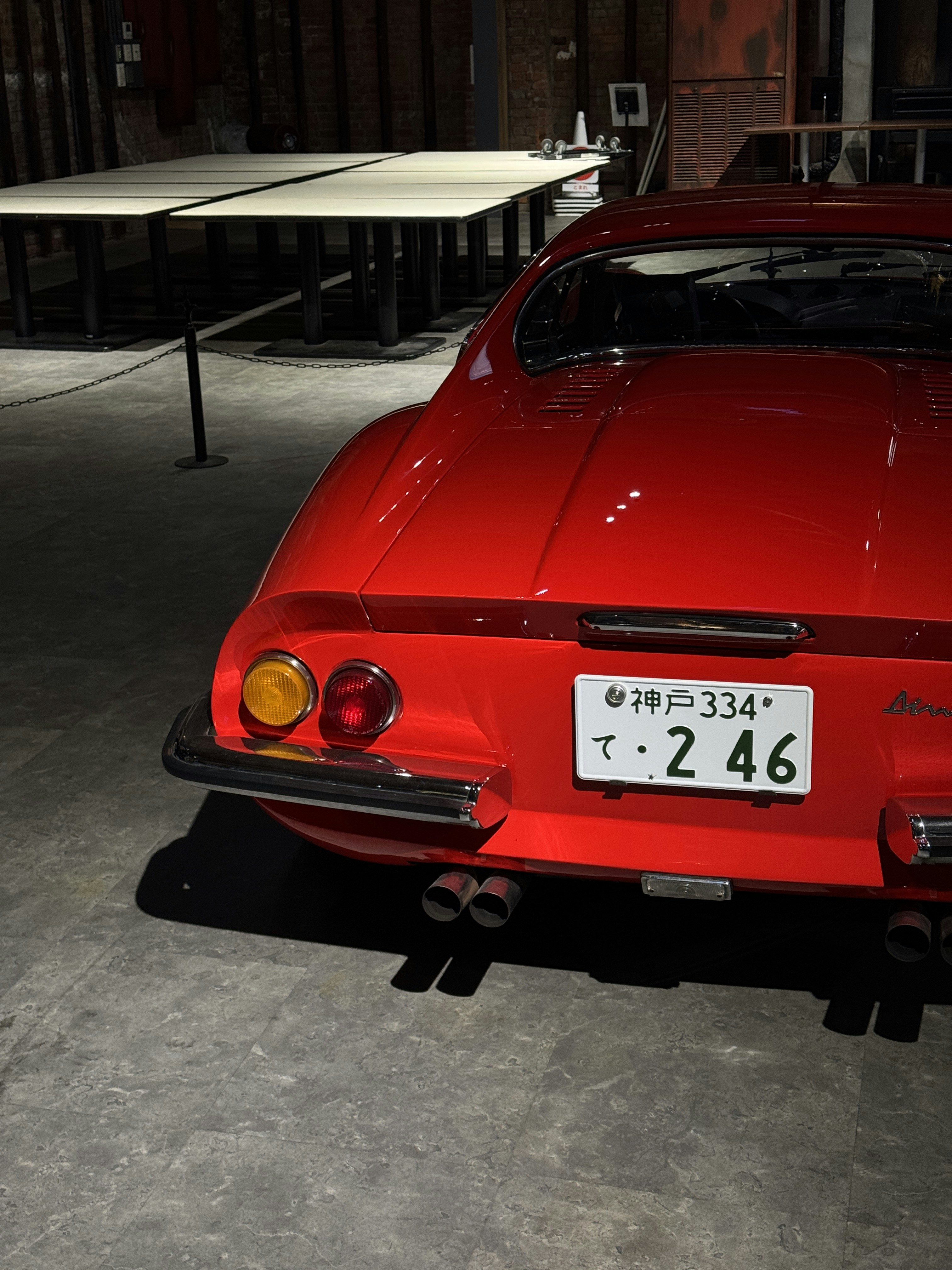 La parte trasera de un deportivo vintage rojo con matrícula japonesa