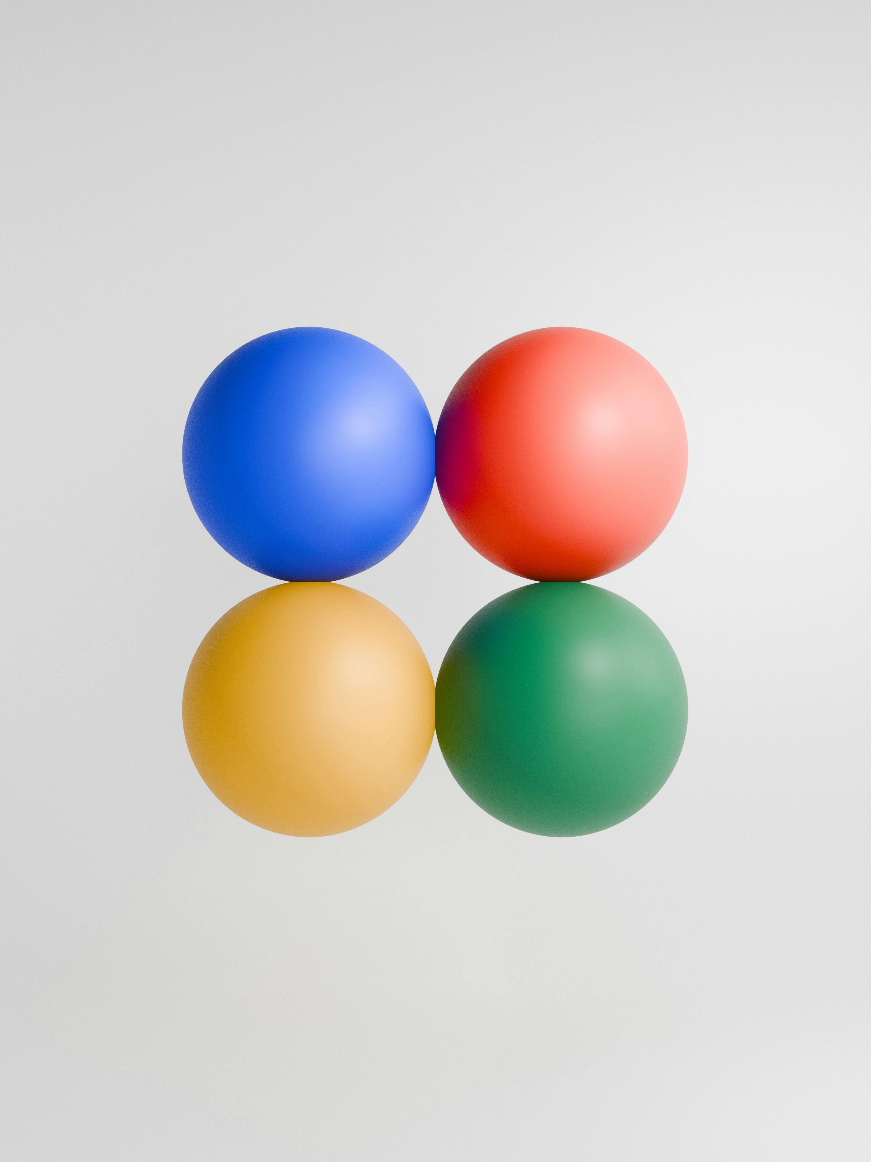 Four colorful spheres in blue, red, yellow, and green against a white background