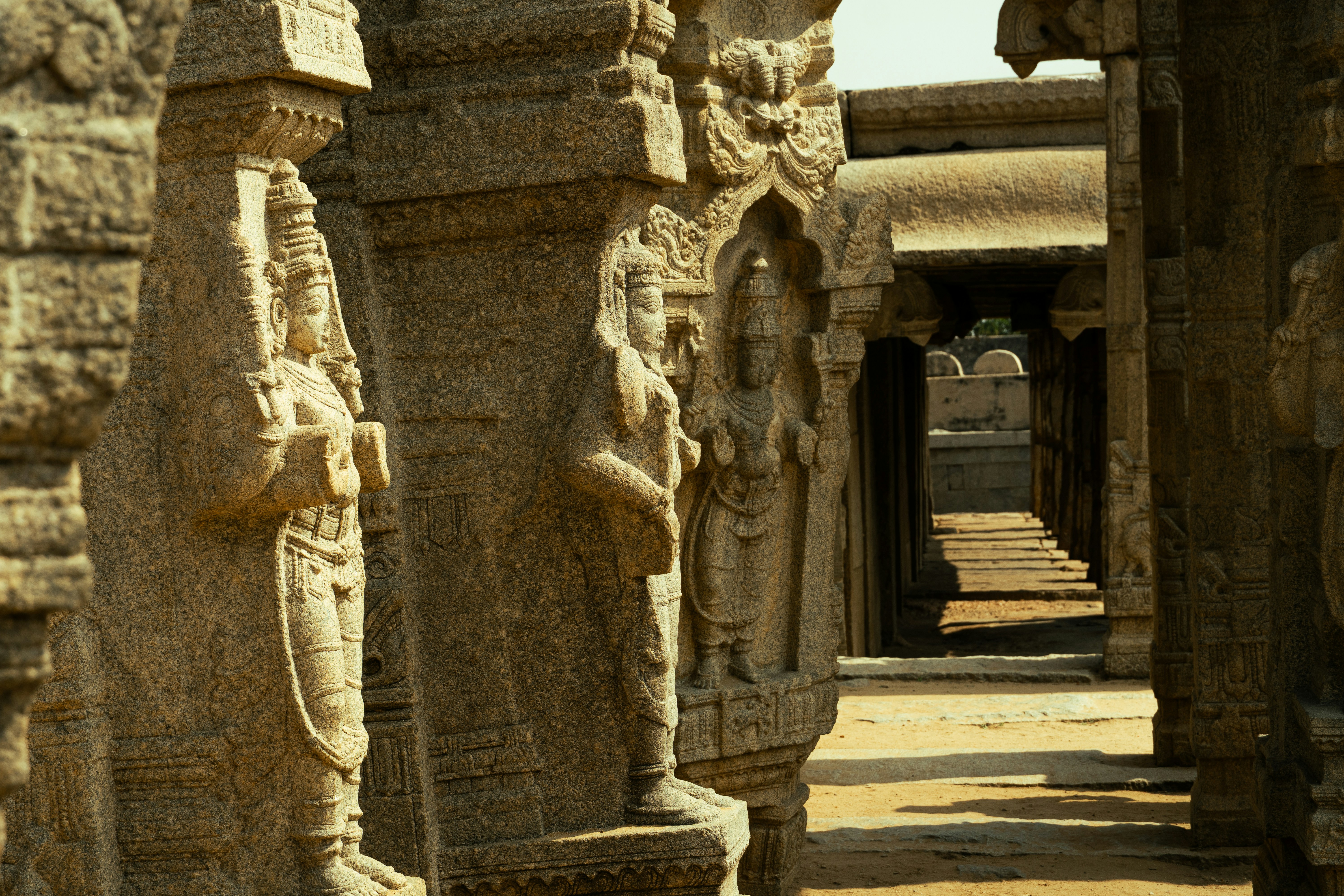 Carved stone figures on pillars in the ancient temple complex of Hampi, India