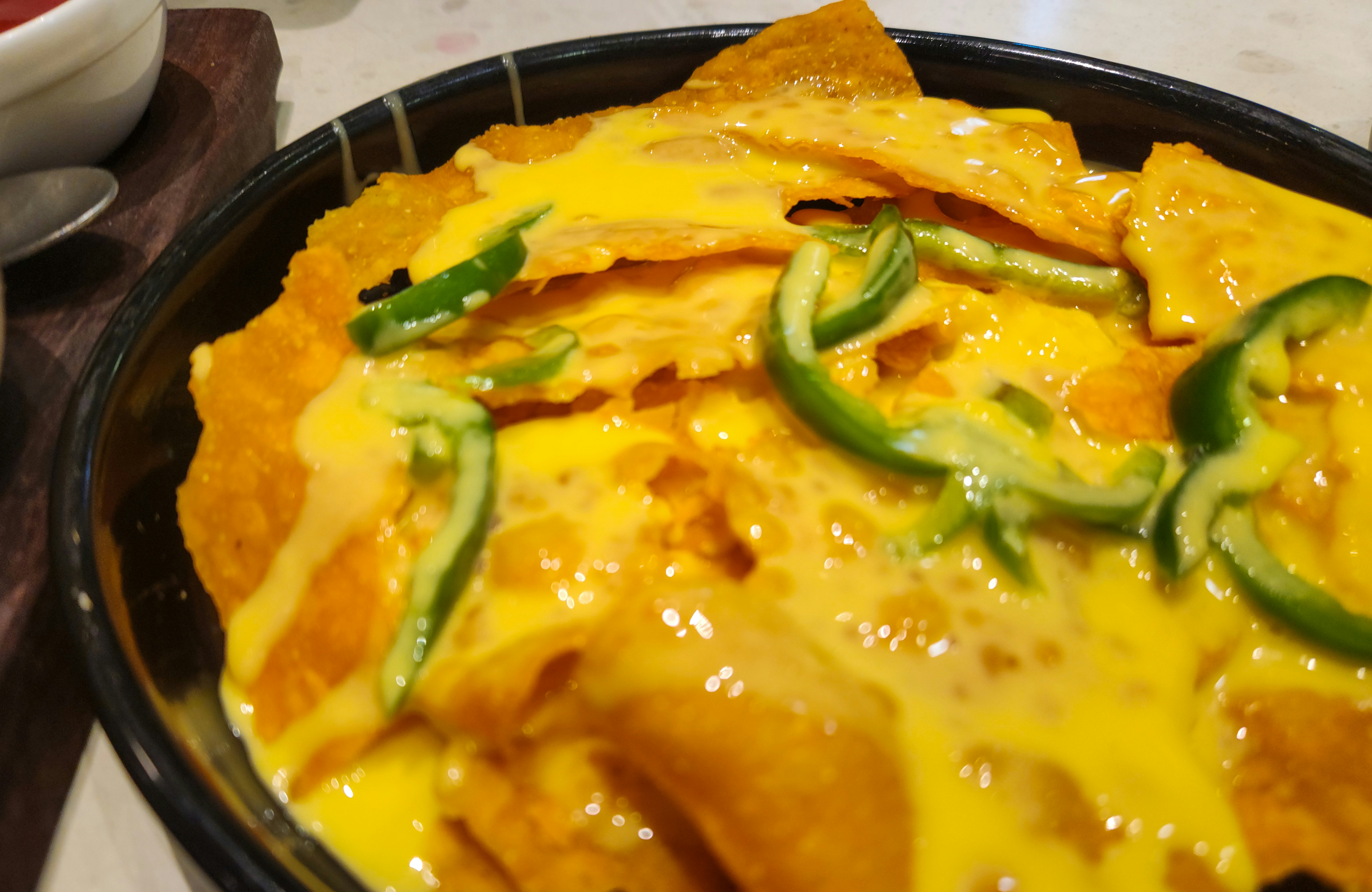 Tortilla chips covered in melted cheese and jalapenos