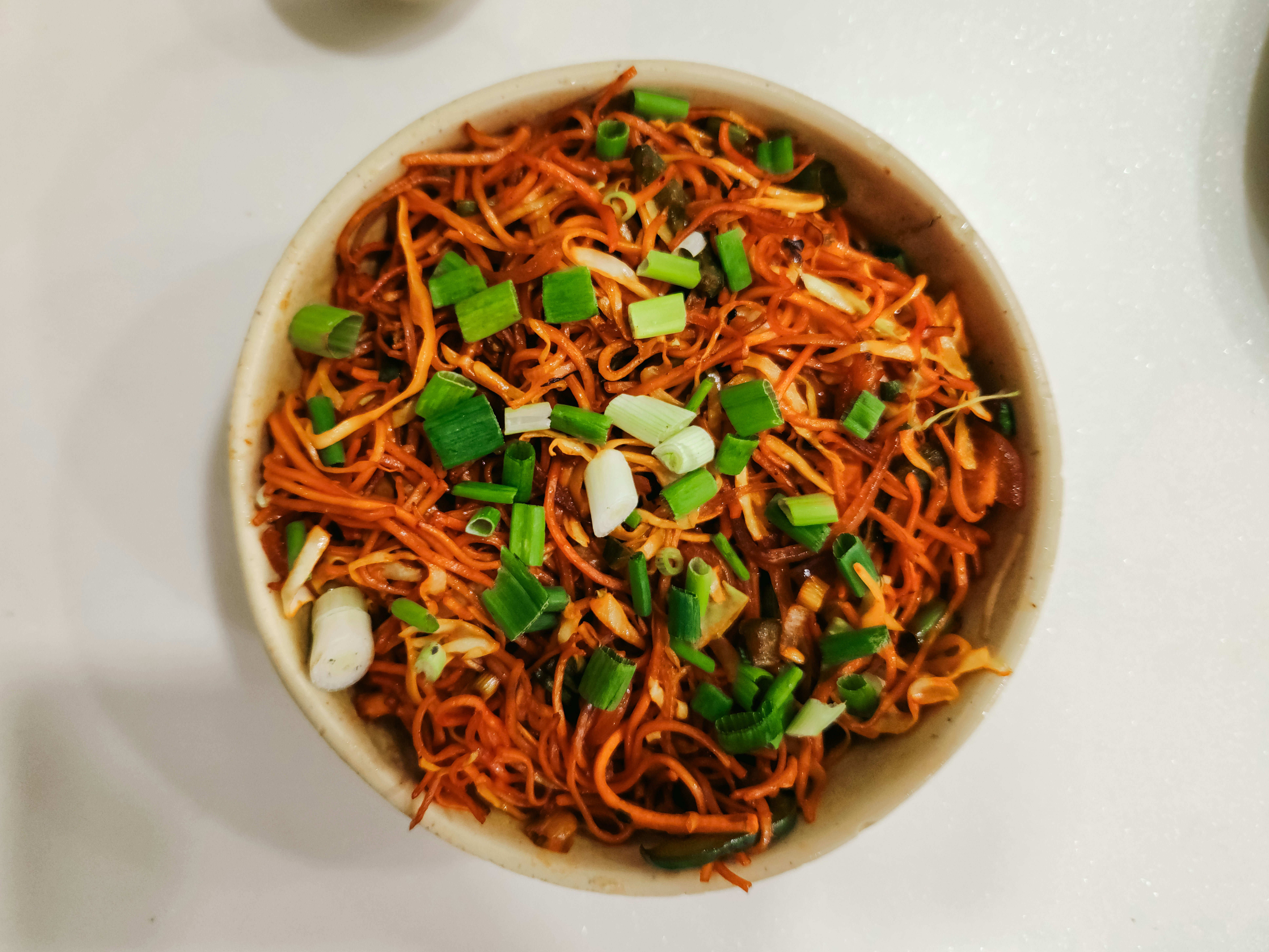 Bowl of stir-fried noodles with spring onion