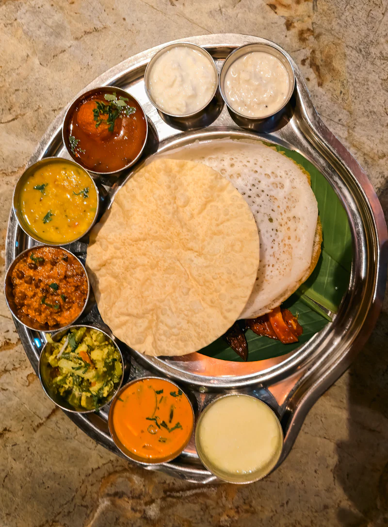 Lace-edged appam with a ring of small vegetable curries