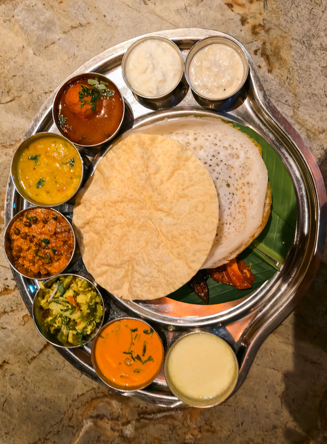 Lace-edged appam with a ring of small vegetable curries