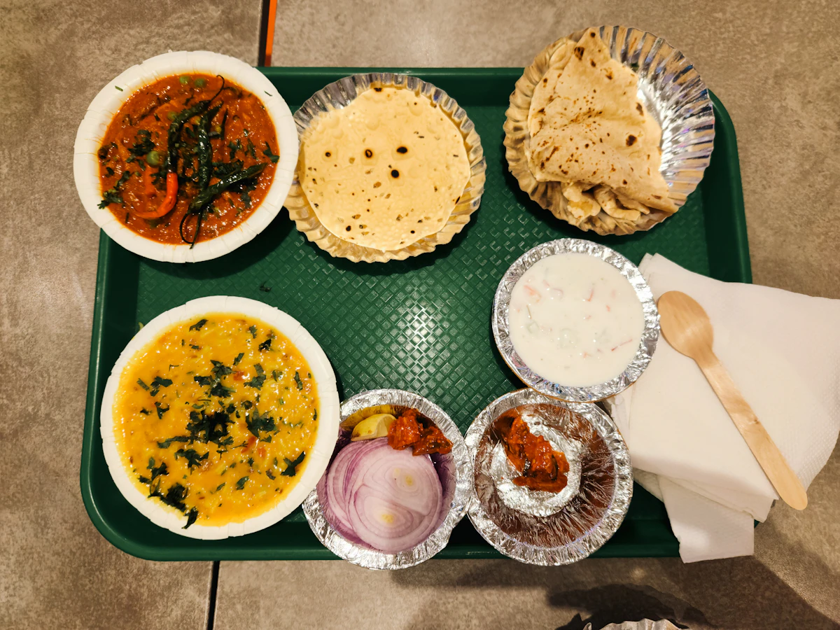 A tray of dal, vegetables, roti and pickle