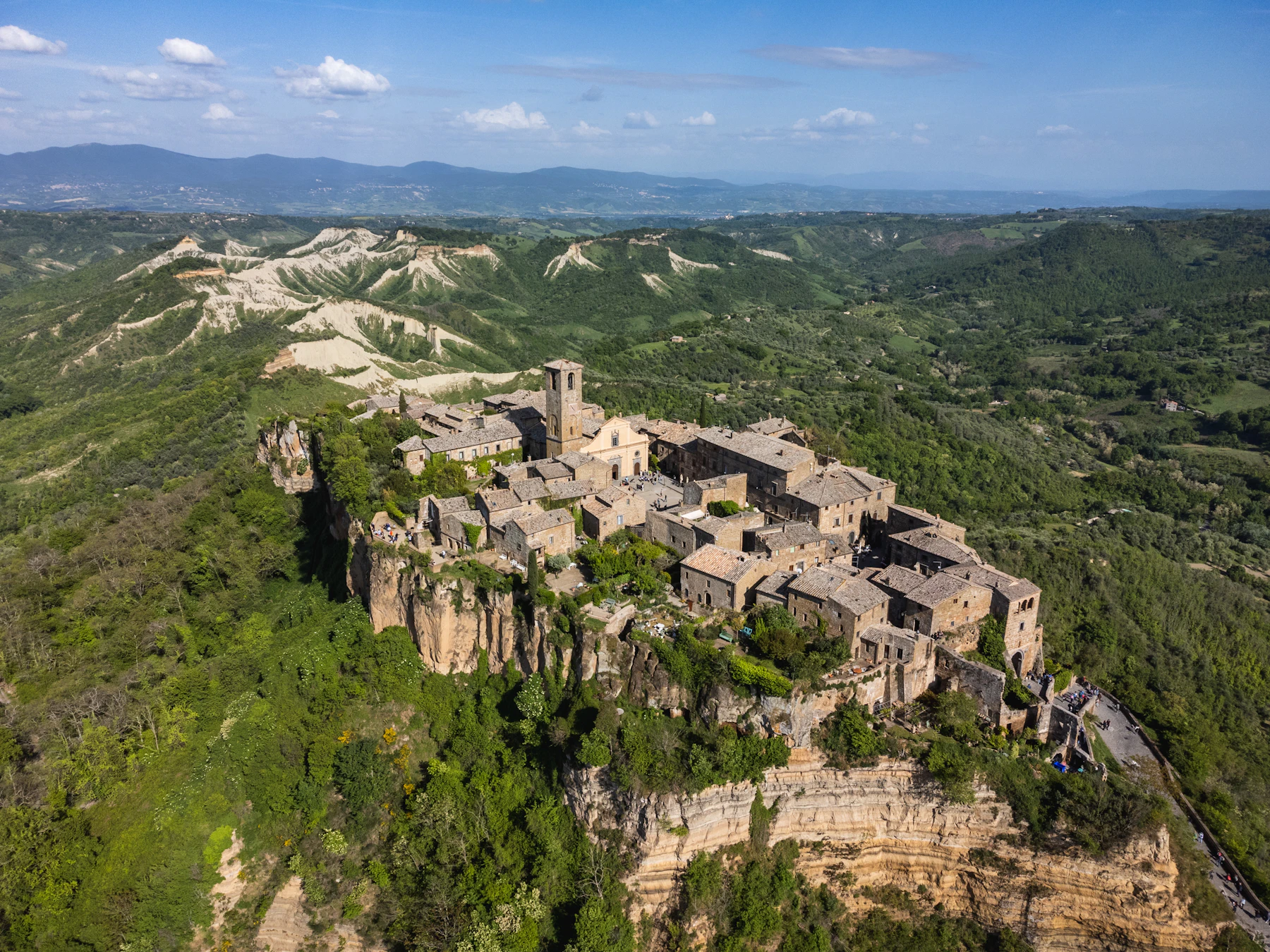 Vista aerea di un borgo italiano su collina, simbolo del radicamento nel territorio