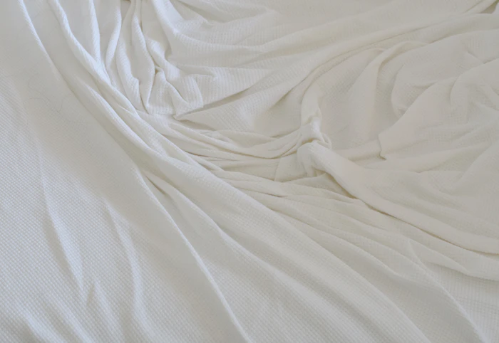 Soft white fabric draped in folds (stand-in for forehead lines)