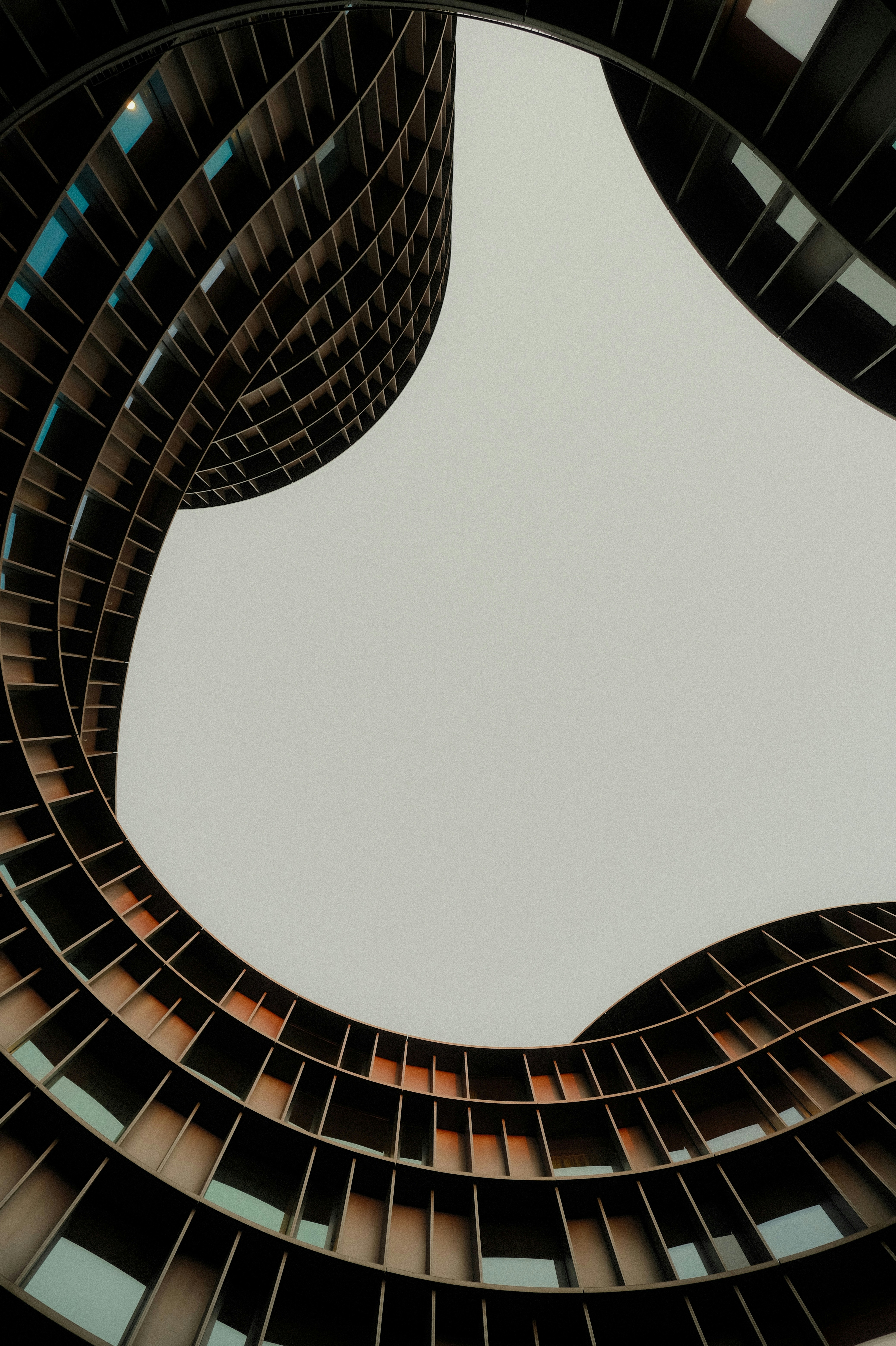 Curved modern building facades with a grid pattern framing the sky - 相关推荐
