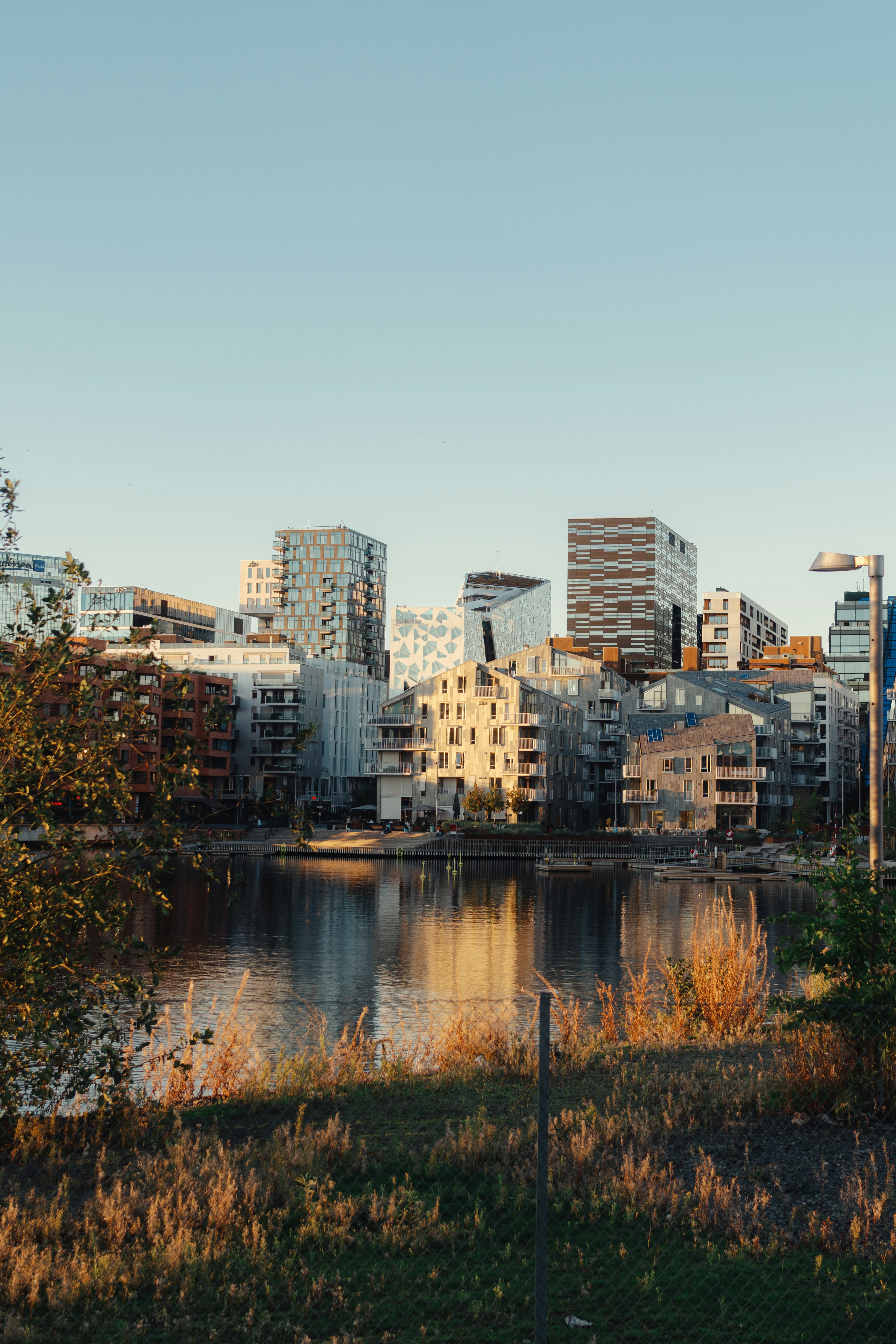 Modern apartment buildings reflecting in the water of the Barcode Project in Oslo