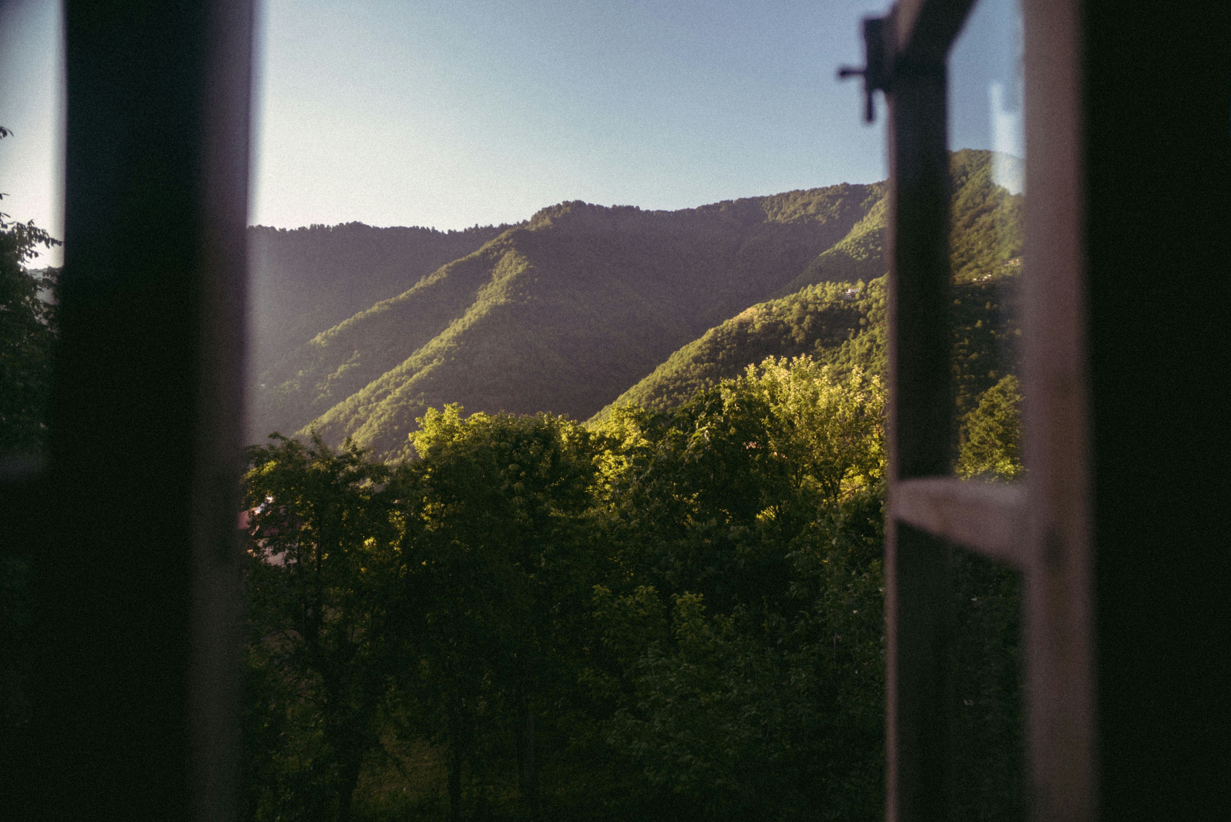 Fenêtre en bois grande ouverte sur les montagnes pour aérer le logement et évacuer l’humidité