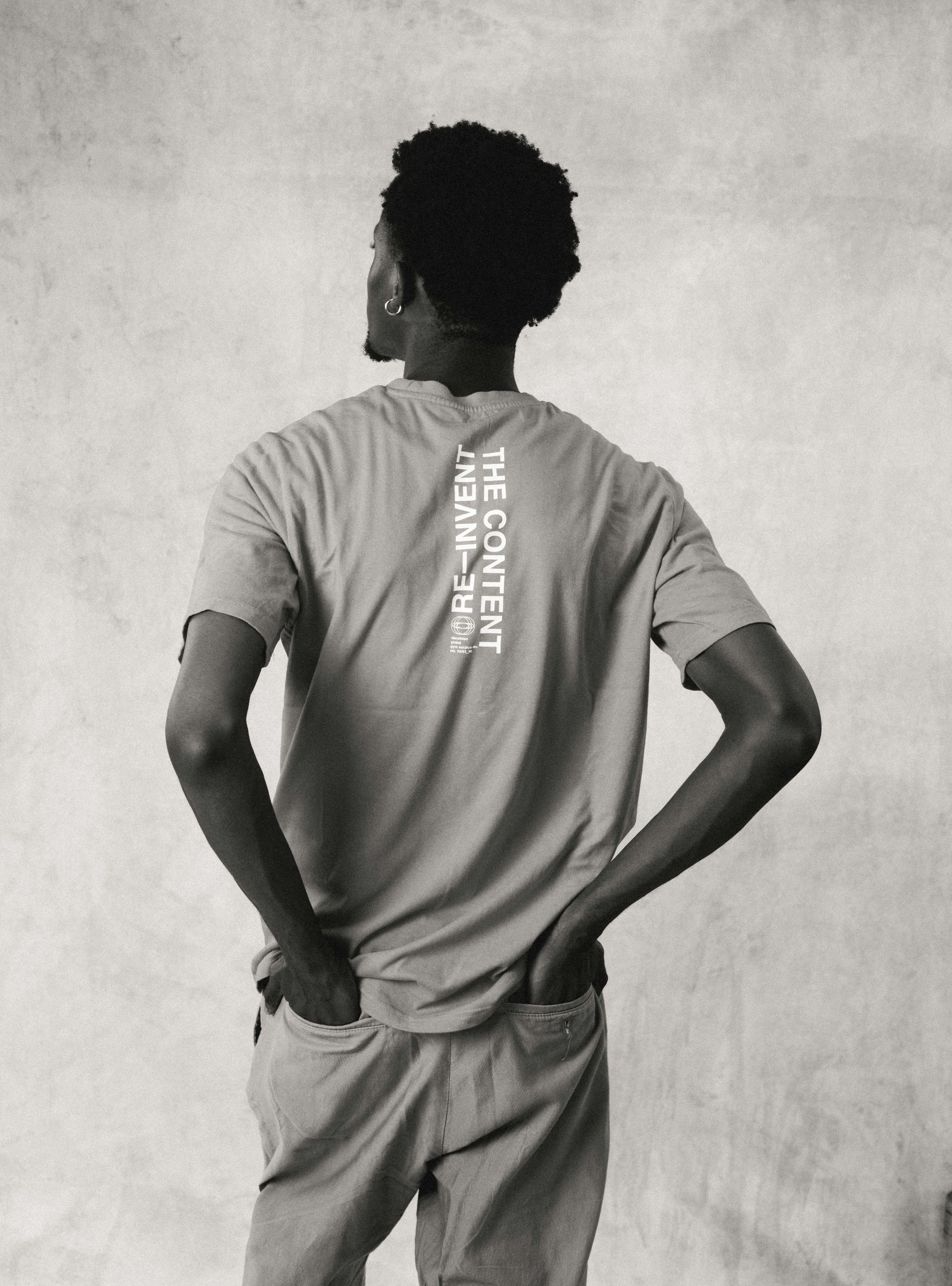 A person seen from behind wearing a t-shirt with the text THE CONTENT RE-INVENT