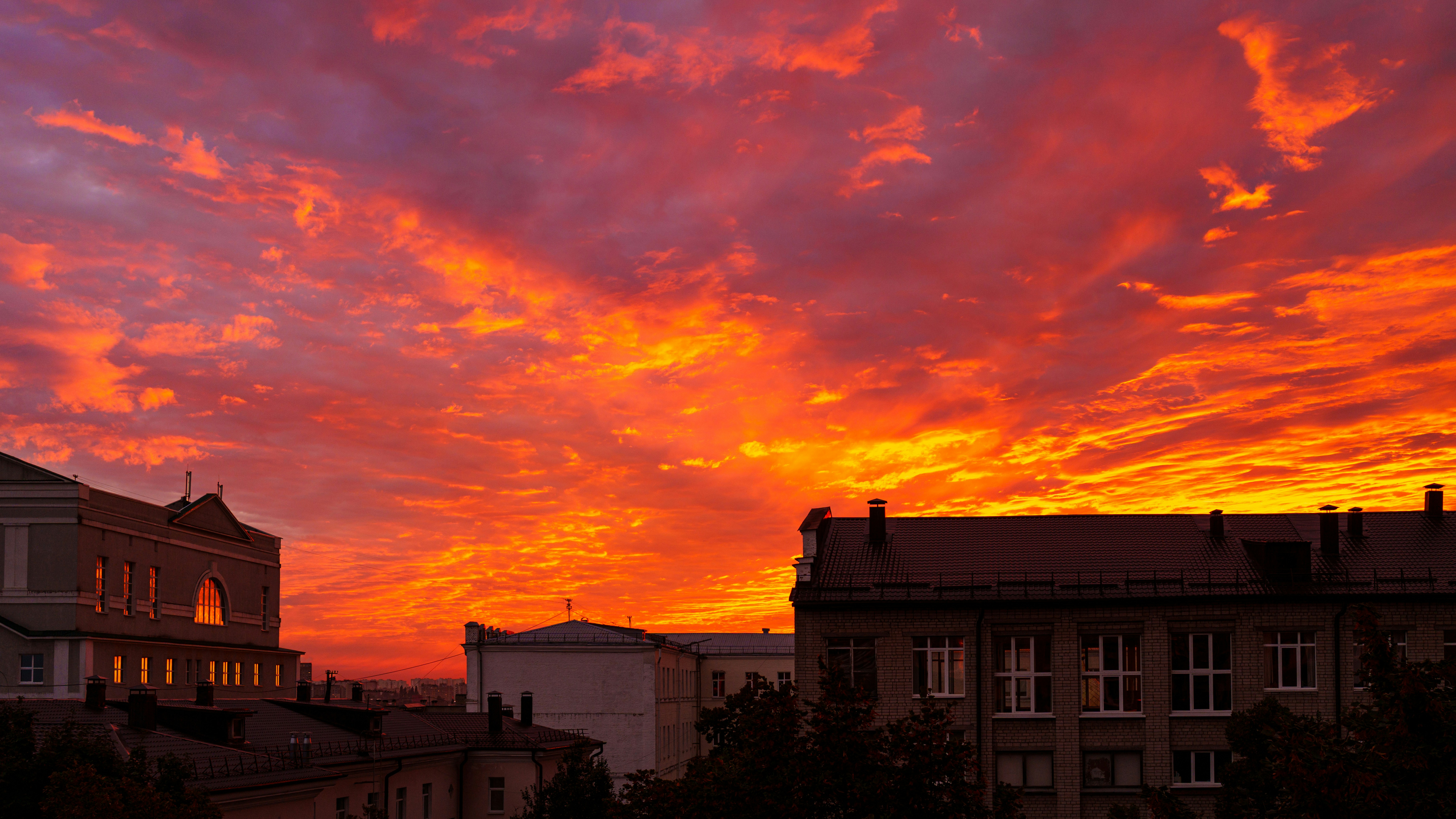 Ein lebendiger orange-roter Himmel über den Dächern der Stadtgebäude