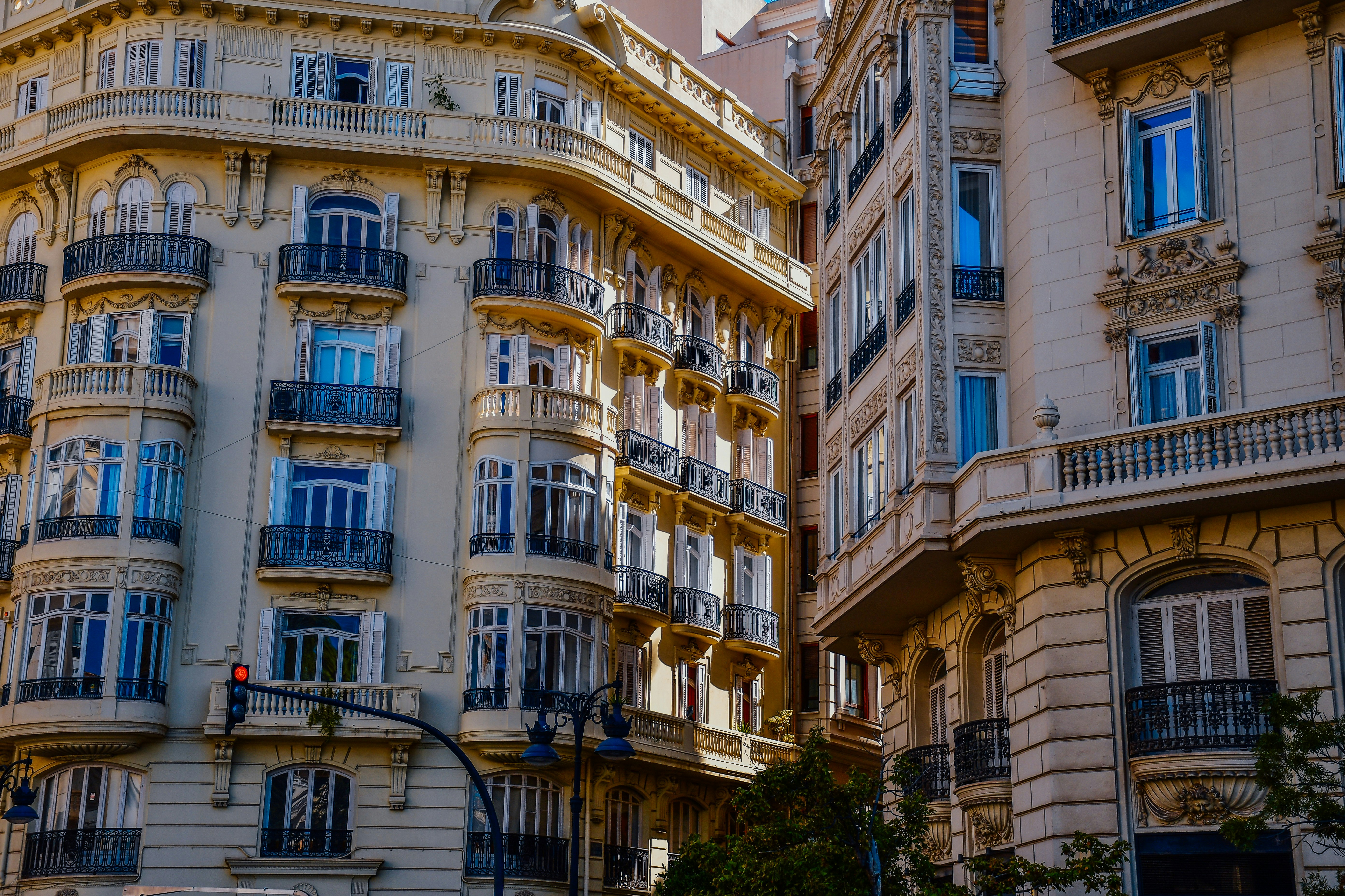 Ornate cream-colored apartment buildings with curved balconies and tall windows in a city