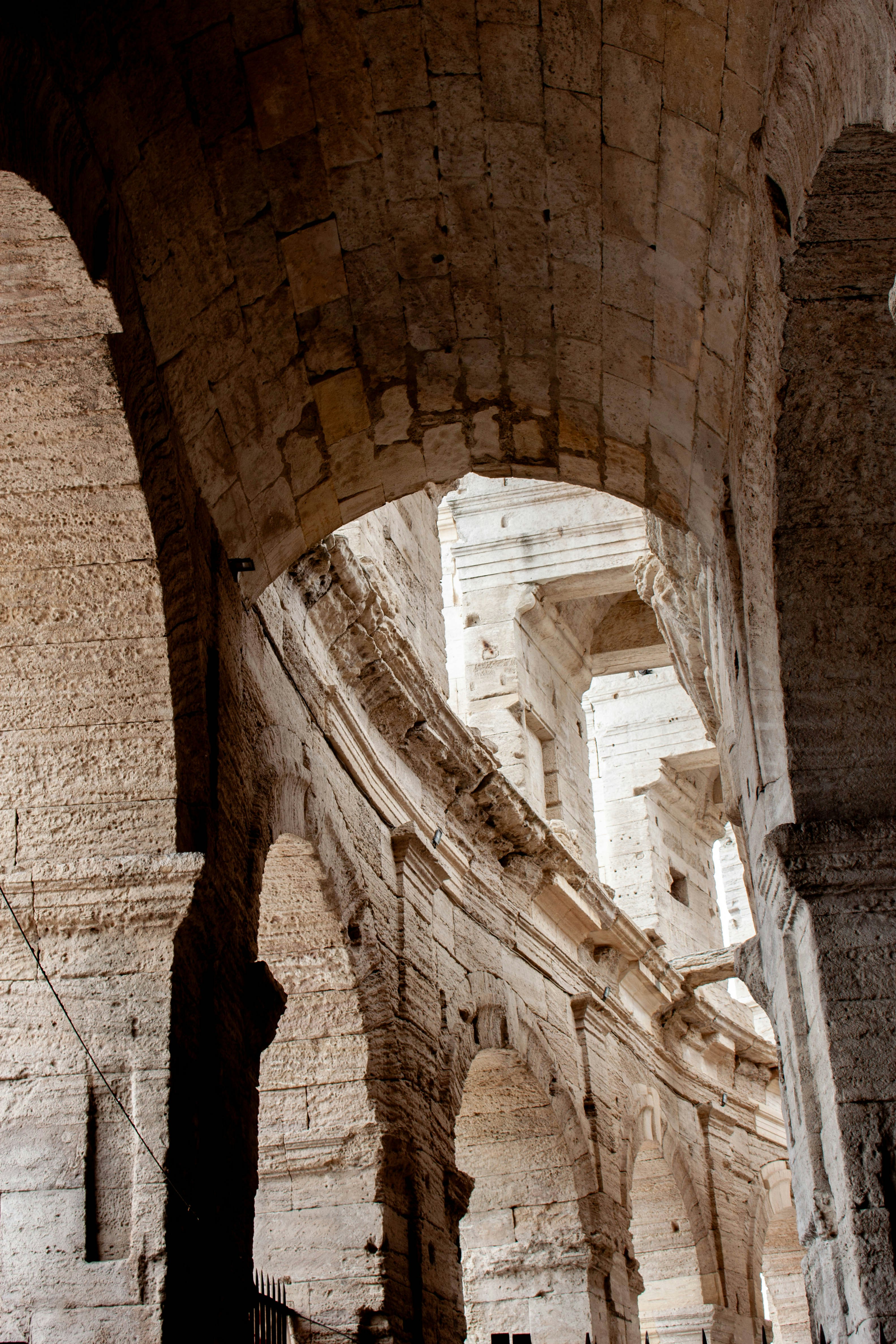Ancient stone arches of the Colosseum in Rome under bright daylight
