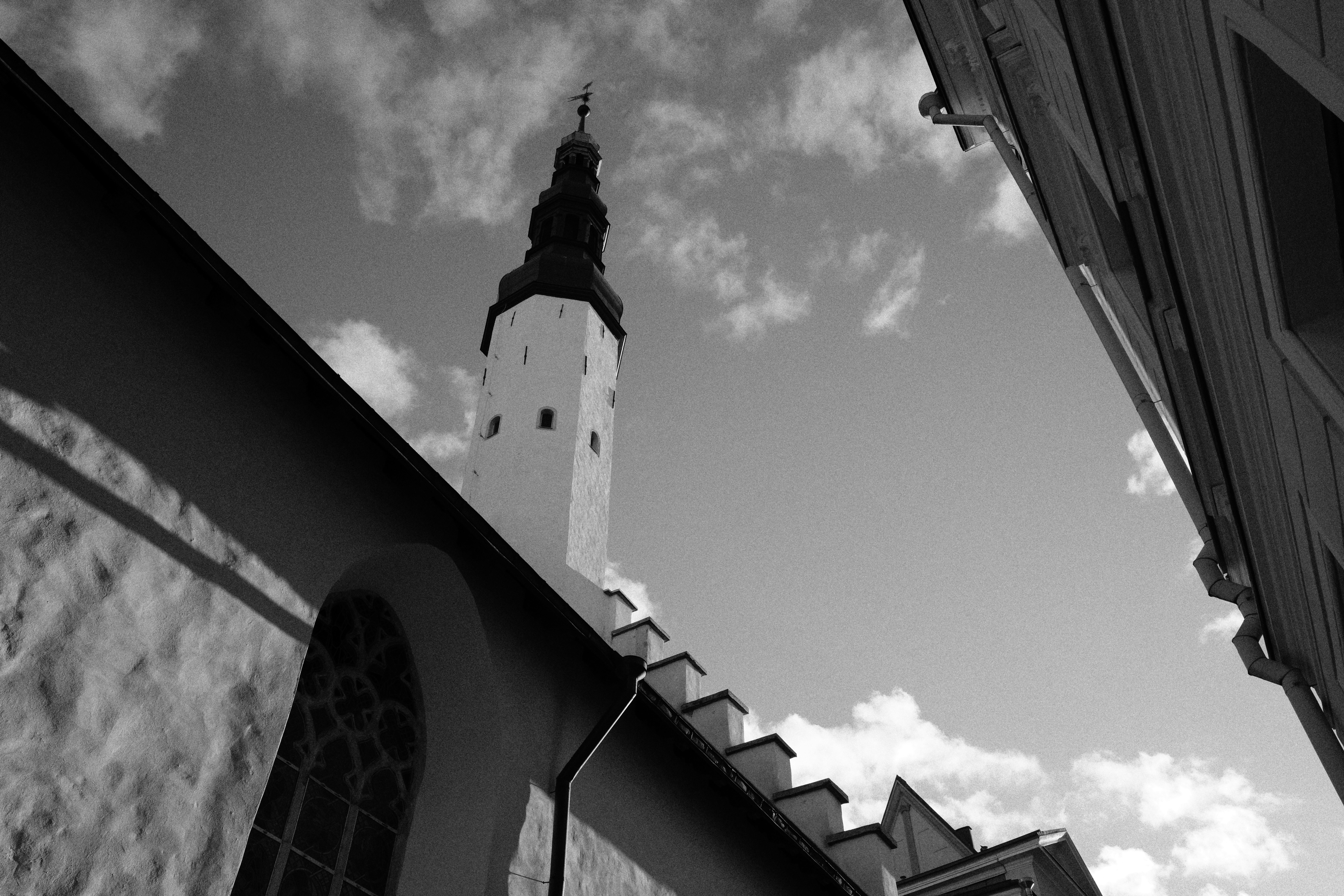 A tall church tower rising above stone walls against a cloudy sky