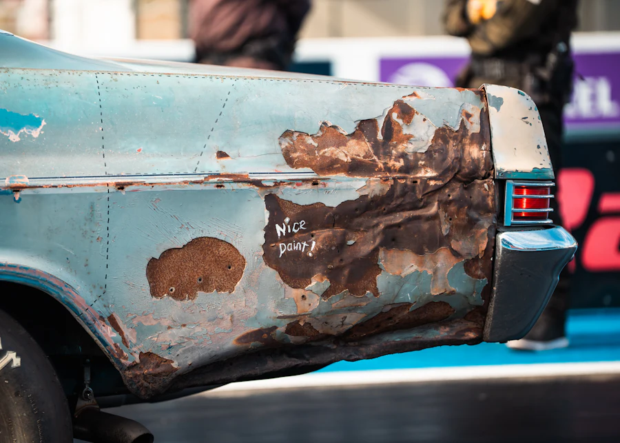 Rust bubbling through the paint on a car's rear quarter panel