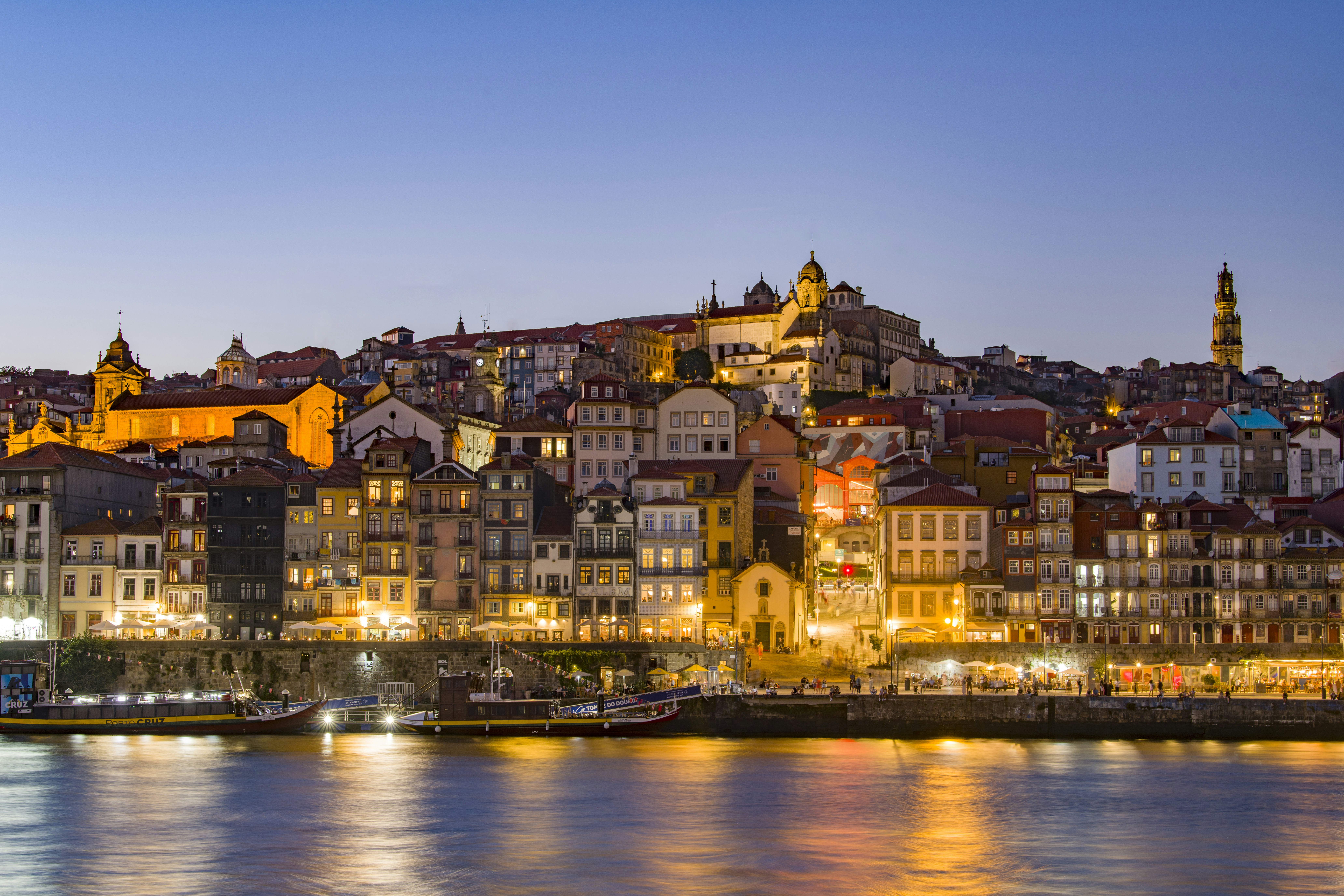 The historic riverside buildings of Porto illuminated at night along the Douro River