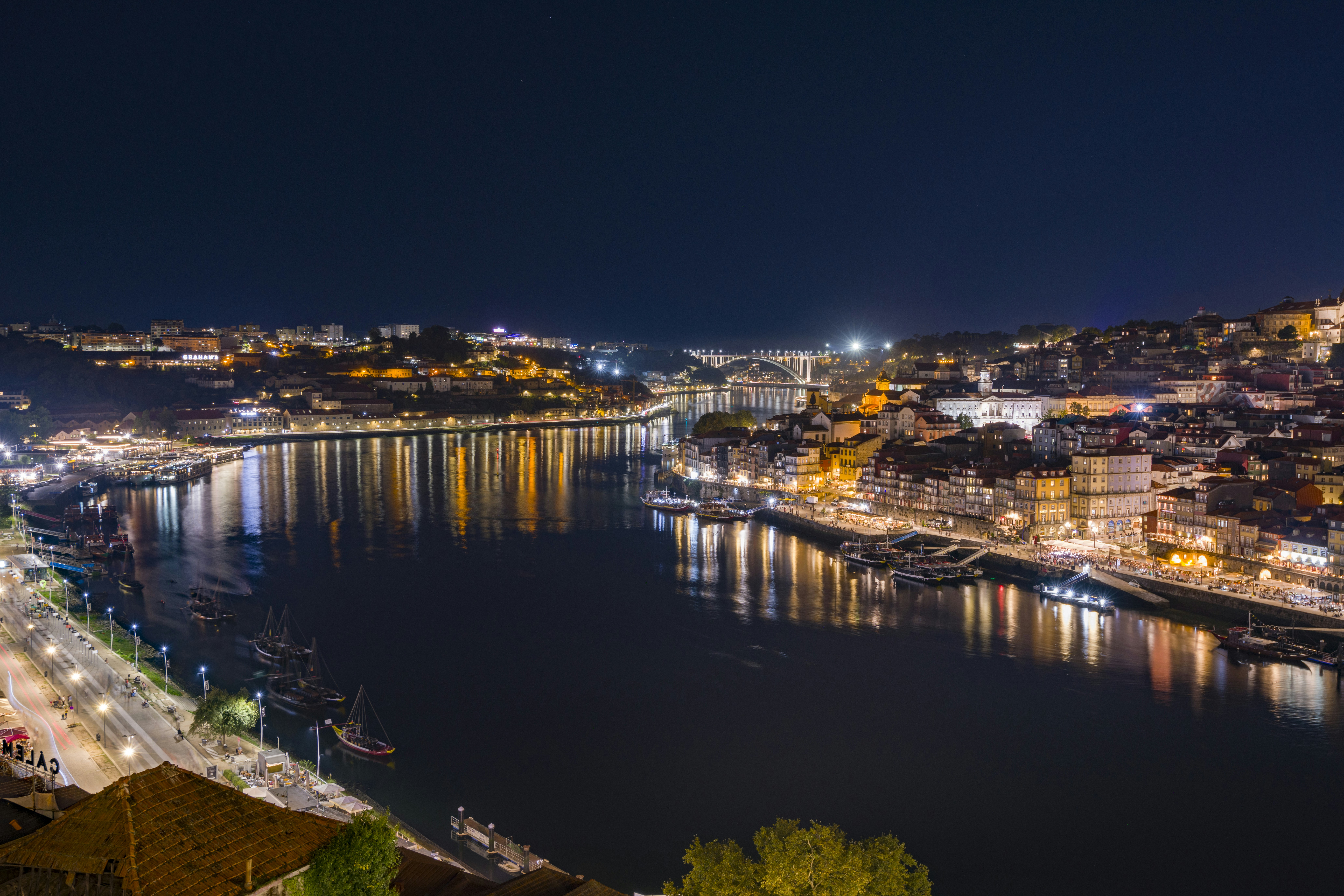 Night view of the Douro River and illuminated buildings in Porto, Portugal