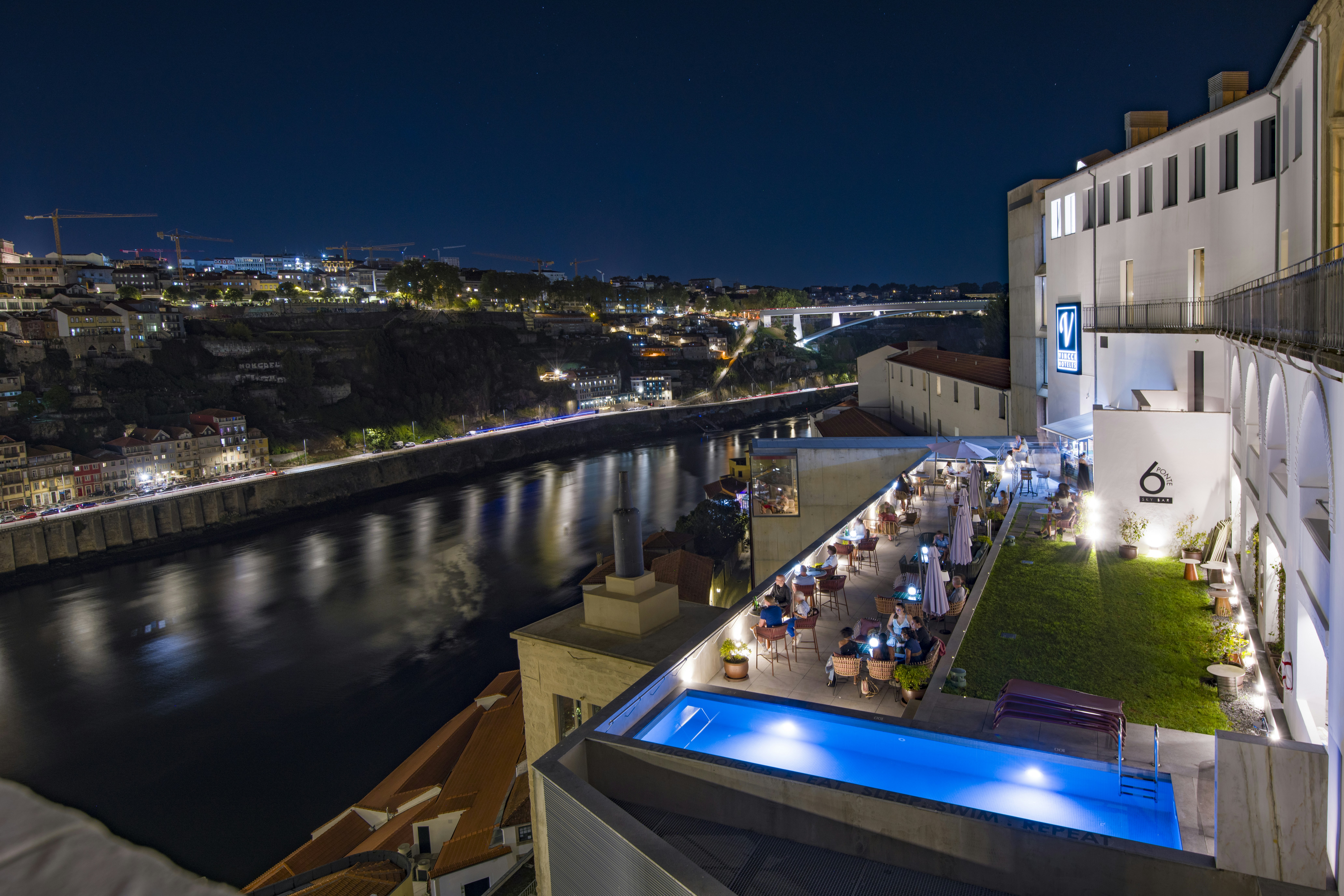 A rooftop terrace with a swimming pool overlooking the Douro River in Porto