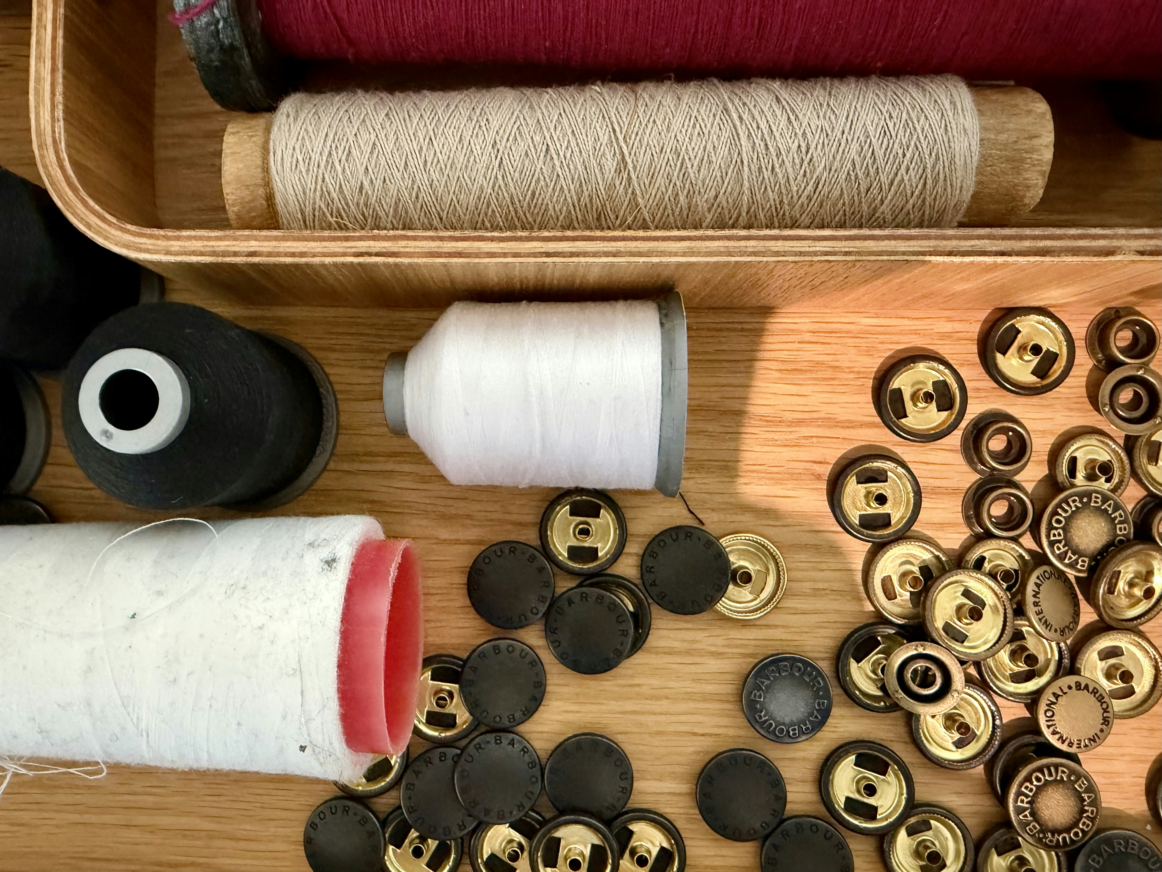Bobines de fil et attaches métalliques pour vêtements sur une surface en bois