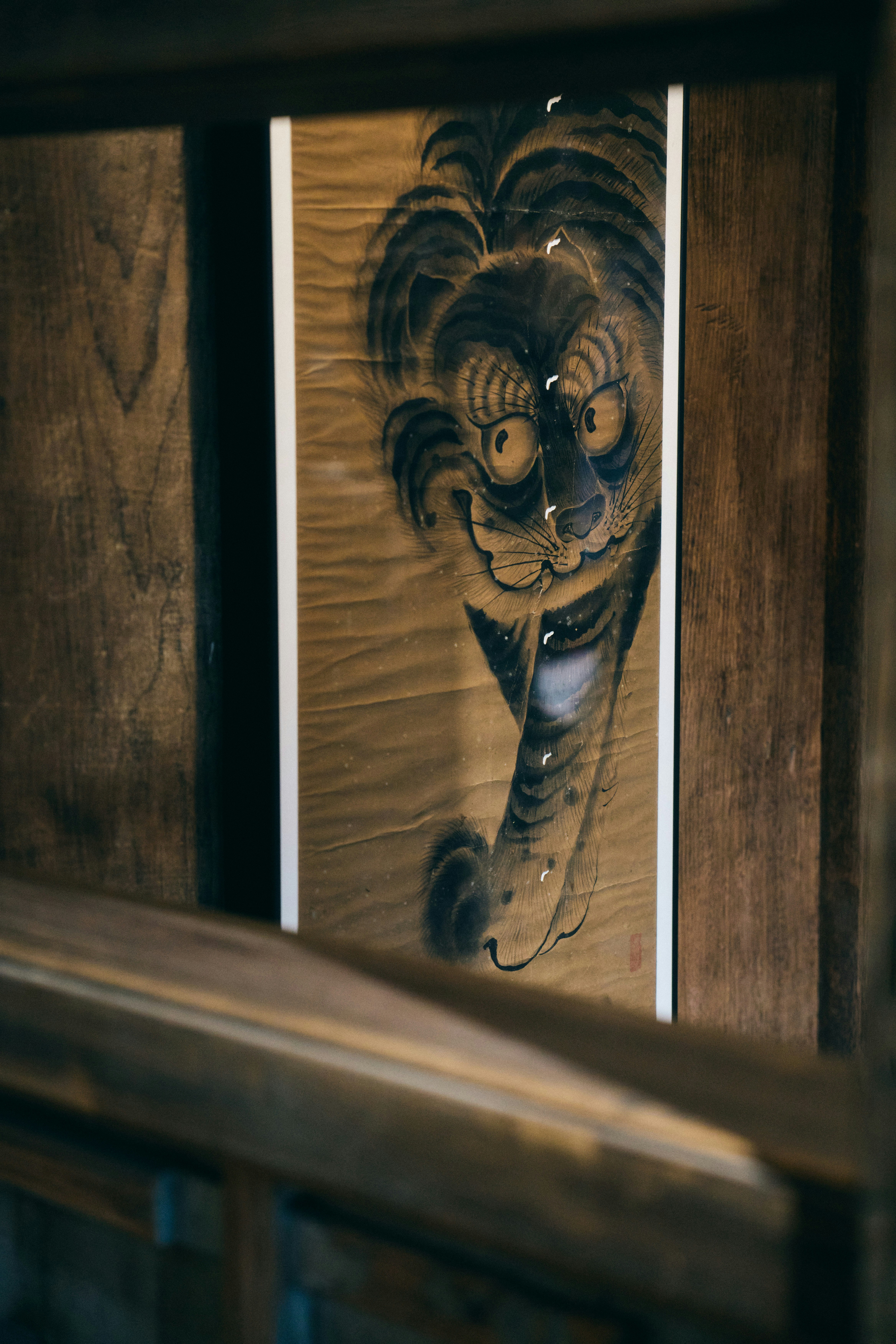 Un dipinto tradizionale a inchiostro di una tigre su un rotolo in una cornice di legno