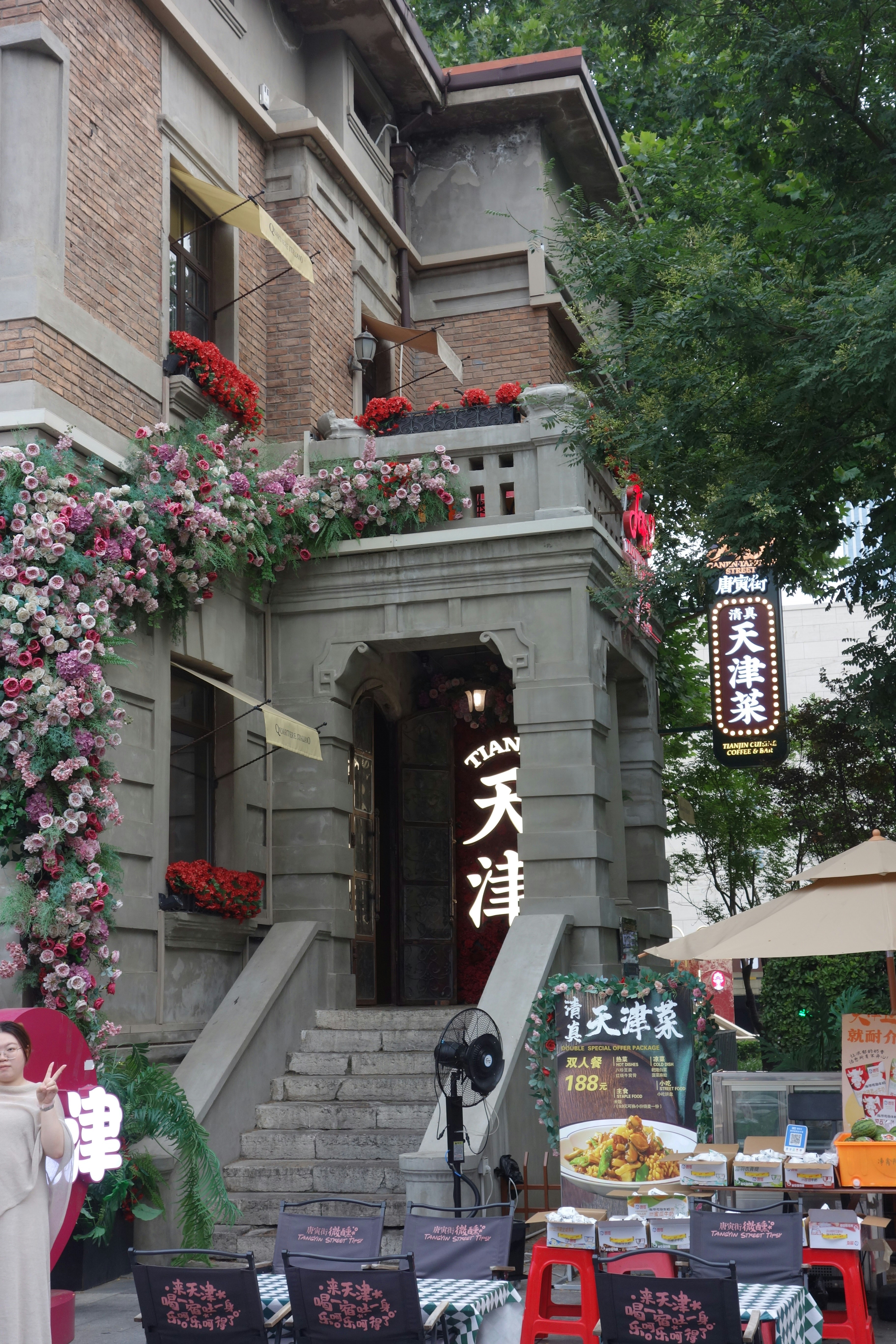 A brick building with floral decorations and a restaurant entrance in Tianjin