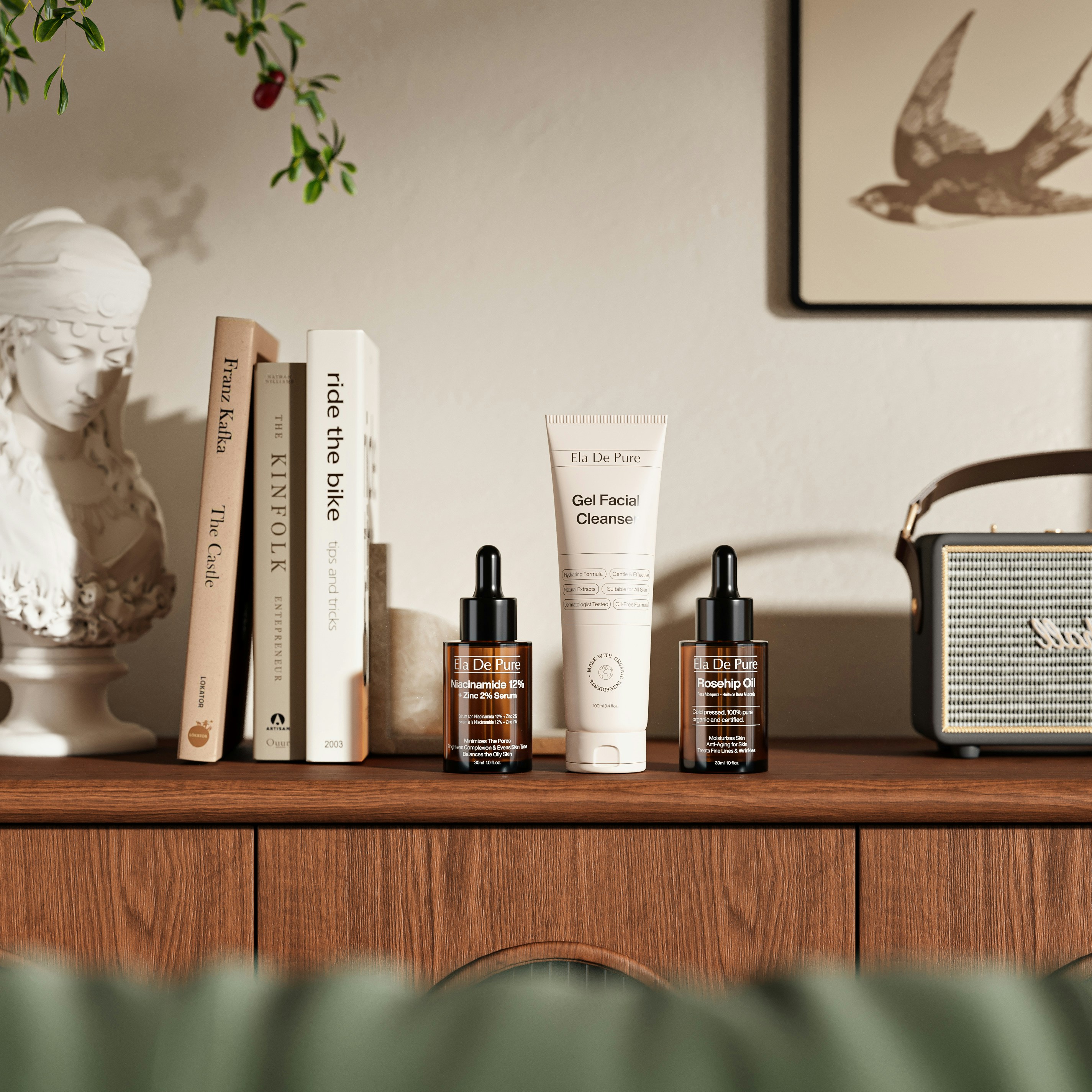 Skincare products including serum and cleanser on a wooden shelf with books and decor