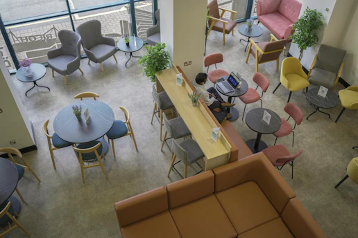 A person working on a laptop at a high counter in a lounge