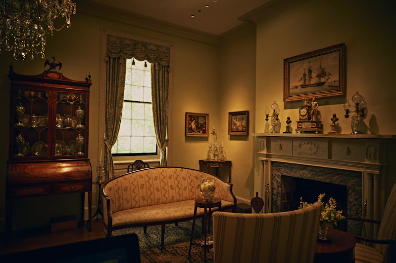 Formal living room with a patterned sofa, fireplace and antique china cabinet