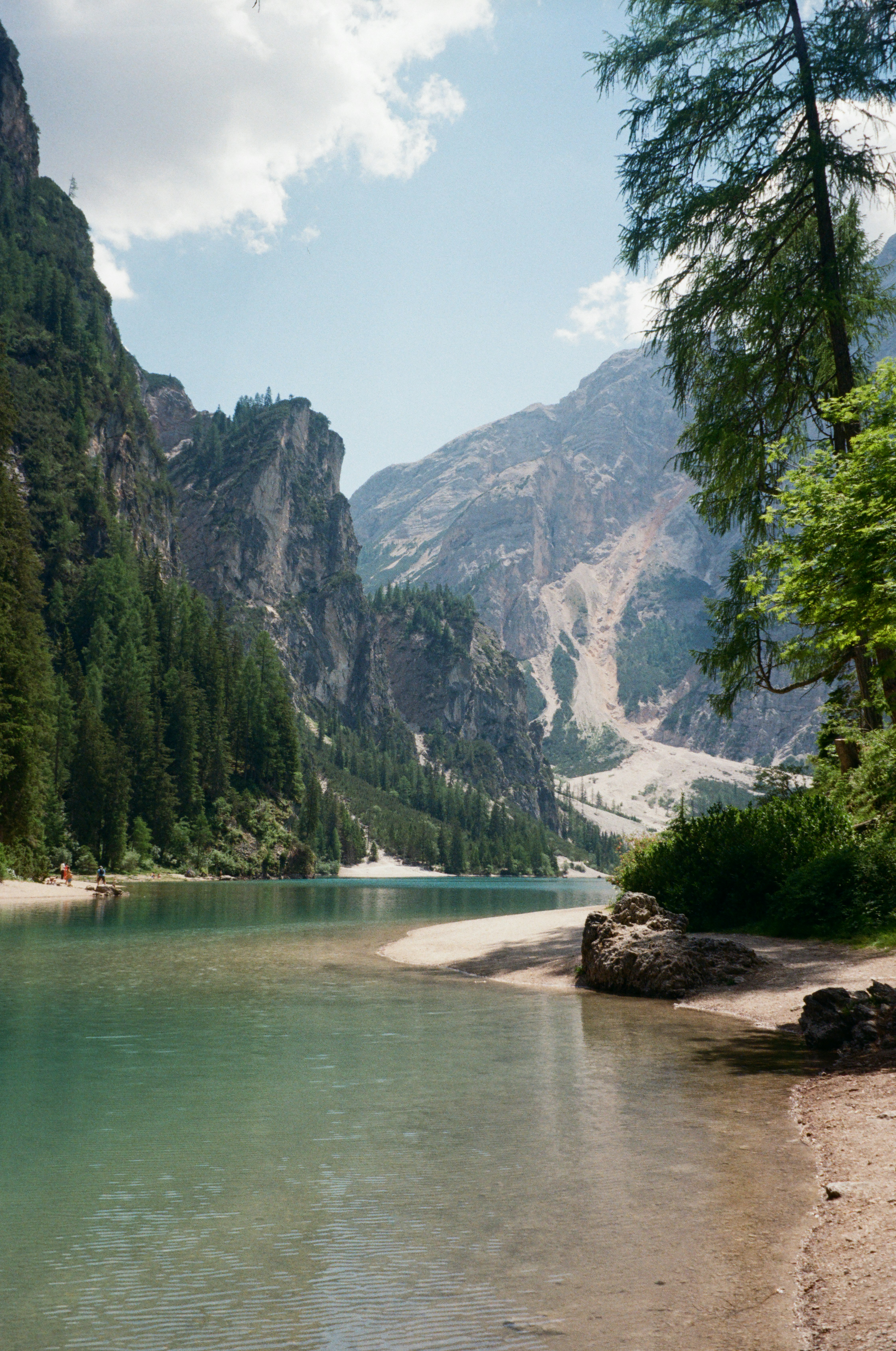 A turquoise lake surrounded by steep rocky mountains and dense pine forests
