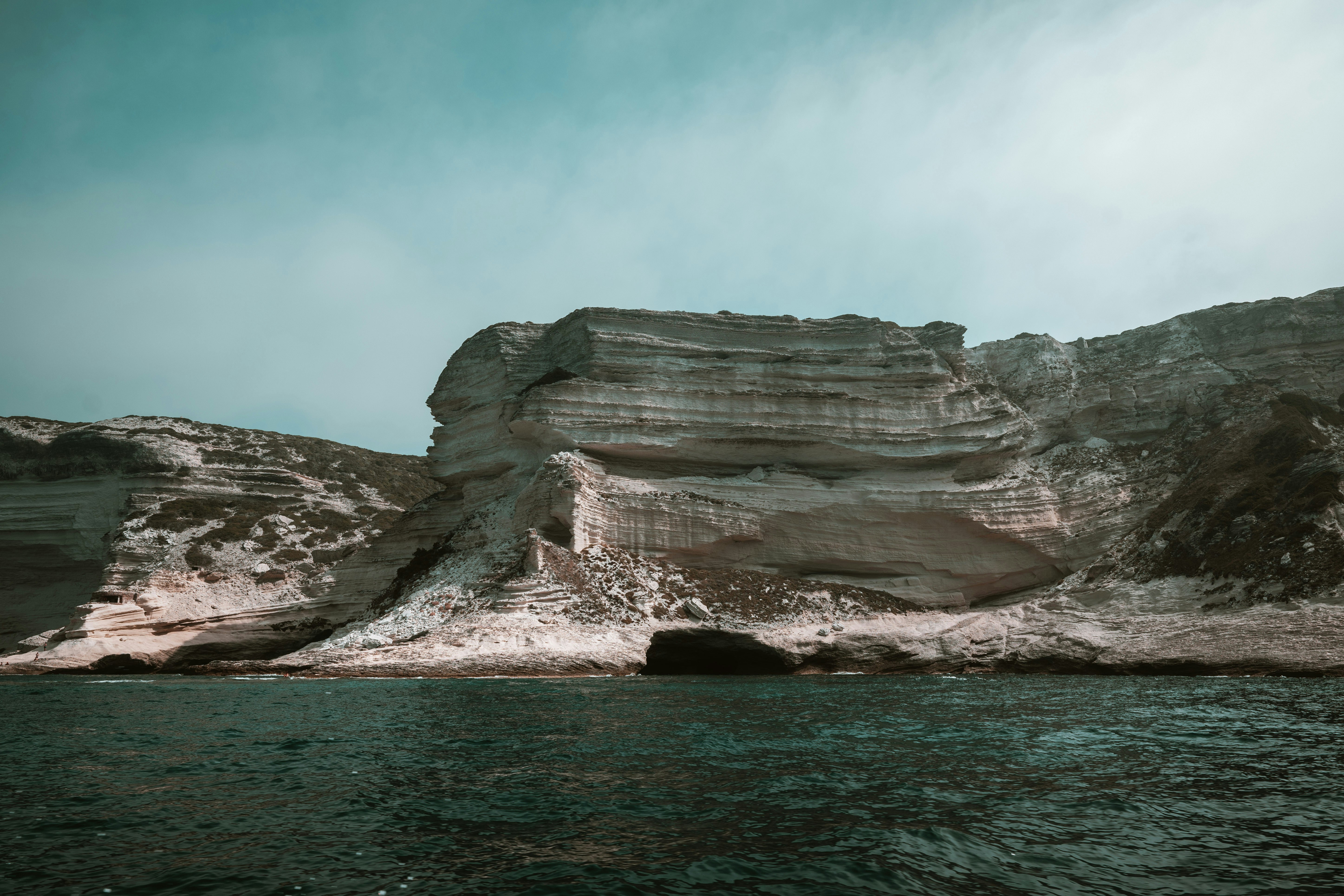 Layered white limestone cliffs rising above dark blue ocean water