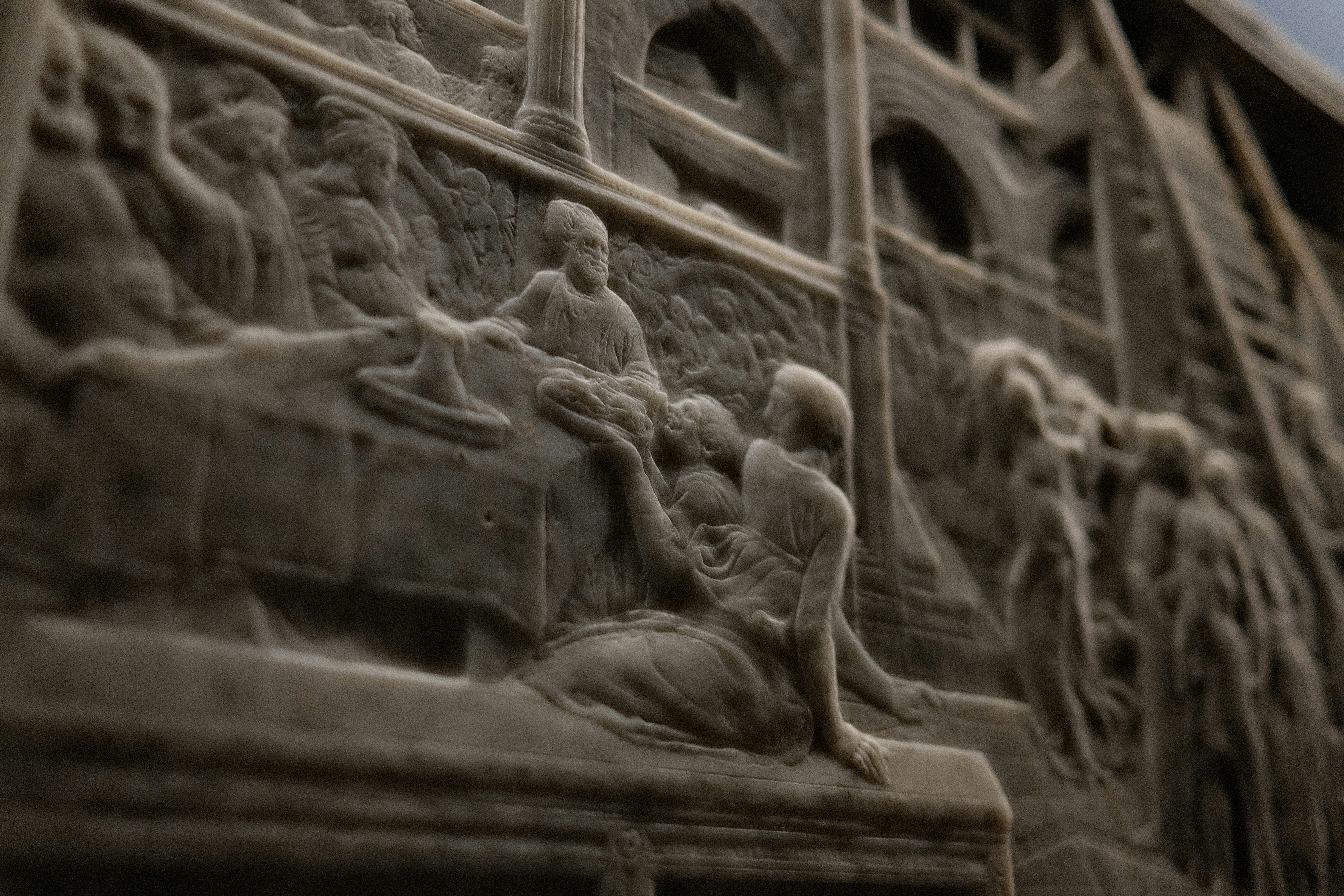 A stone relief carving depicting figures at a table in a shallow perspective