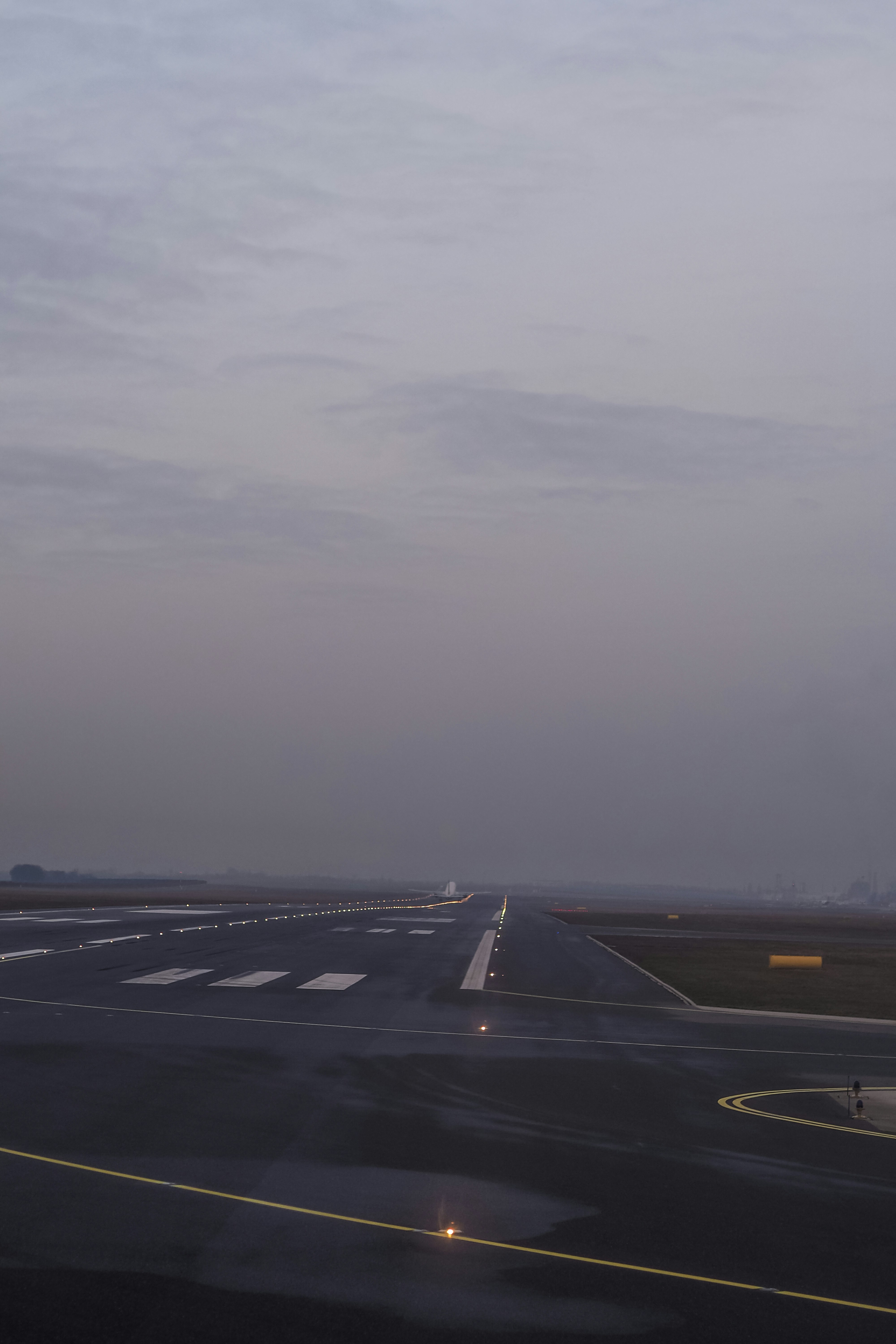An airplane taking off from a runway under a grey overcast sky