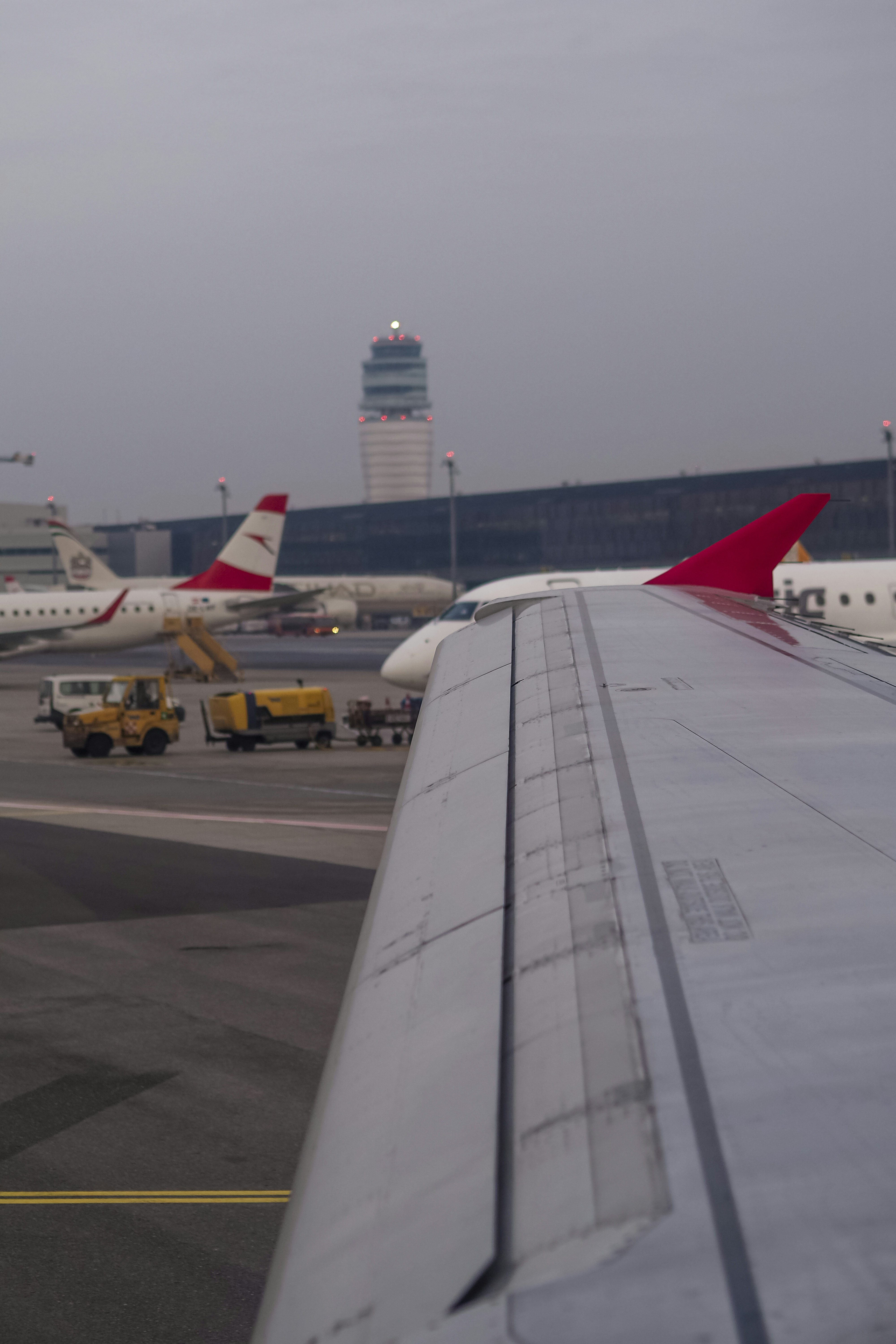 View from an airplane window of an airport tarmac with a control tower